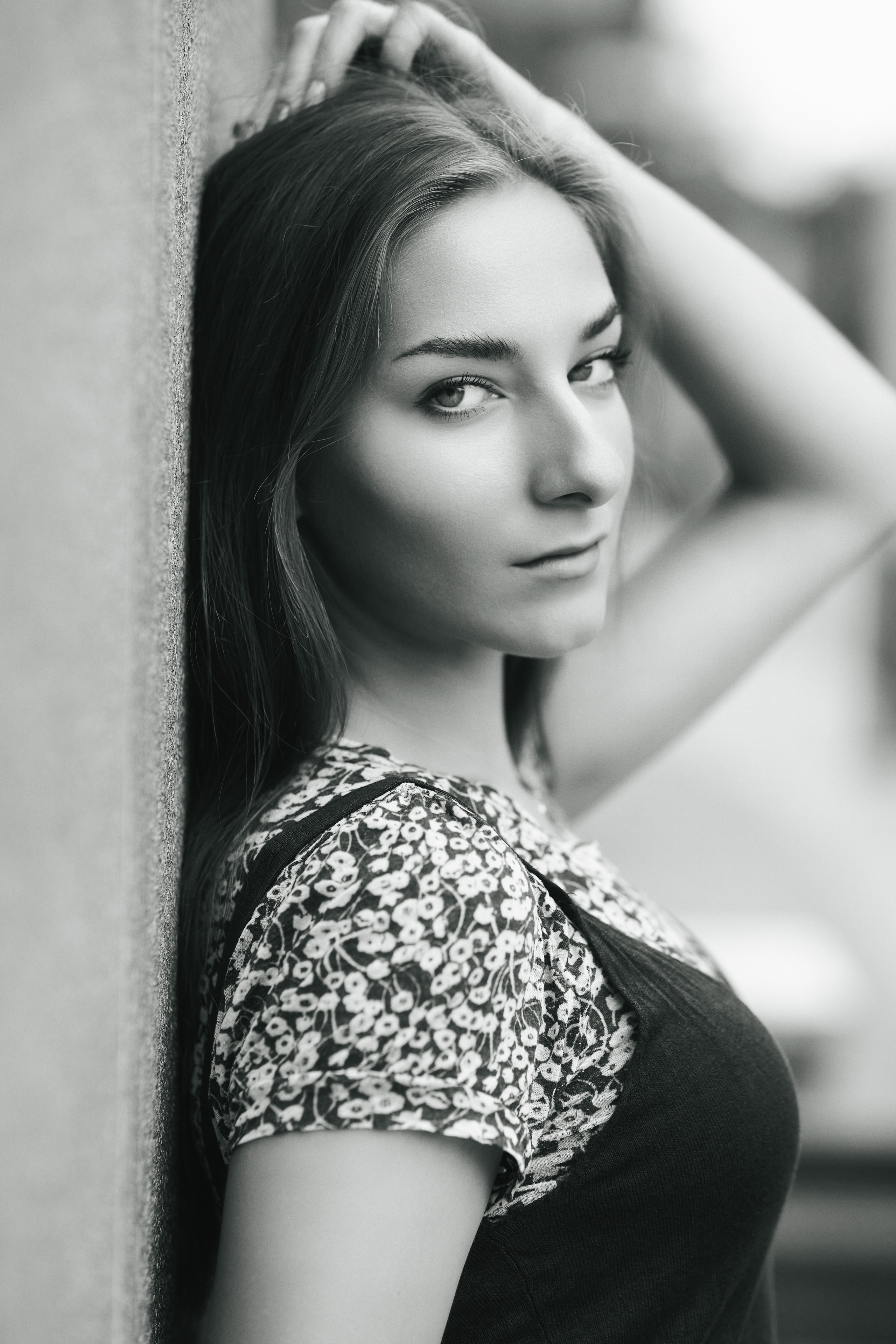 Любовь - темноволосая модель на улице в городе, одетая в элегантное платье, которое придает ей очарование.