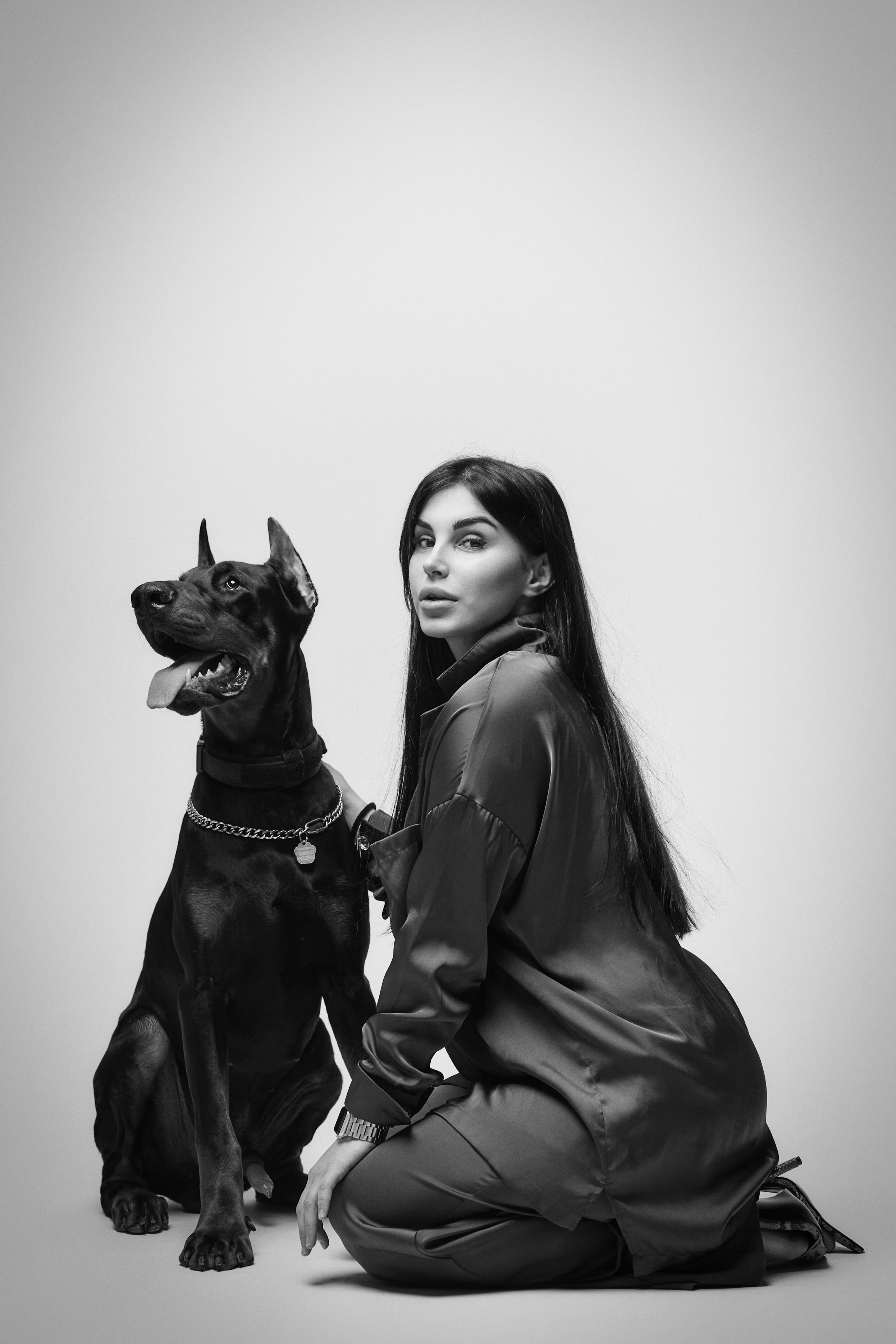 В платье на светлом фоне студии темноволосая модель Карина выглядит элегантно и изящно, словно настоящая леди.