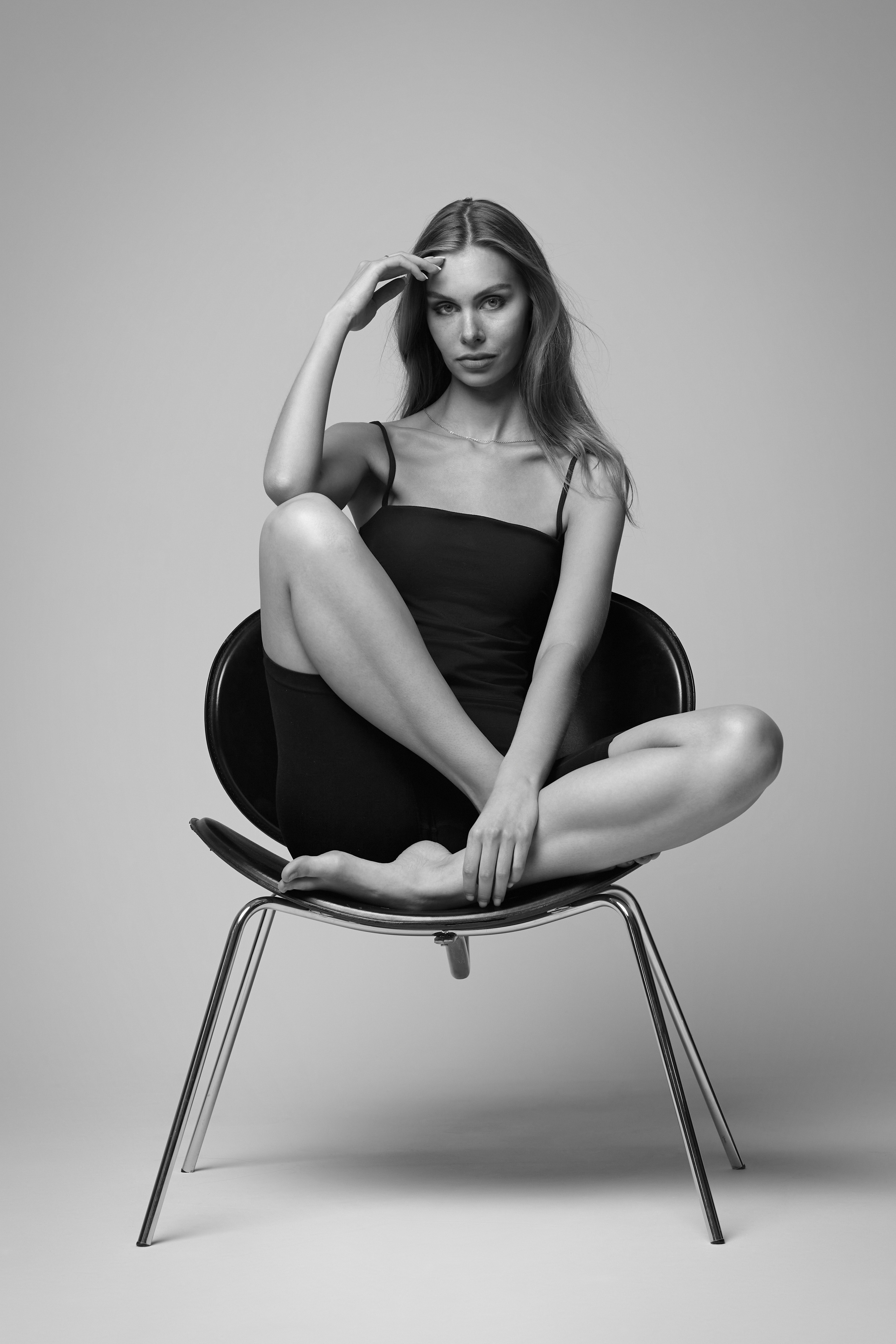 Шляпа и очки в образе темноволосой девушки на светлом фоне подчёркивают её индивидуальность и стиль.