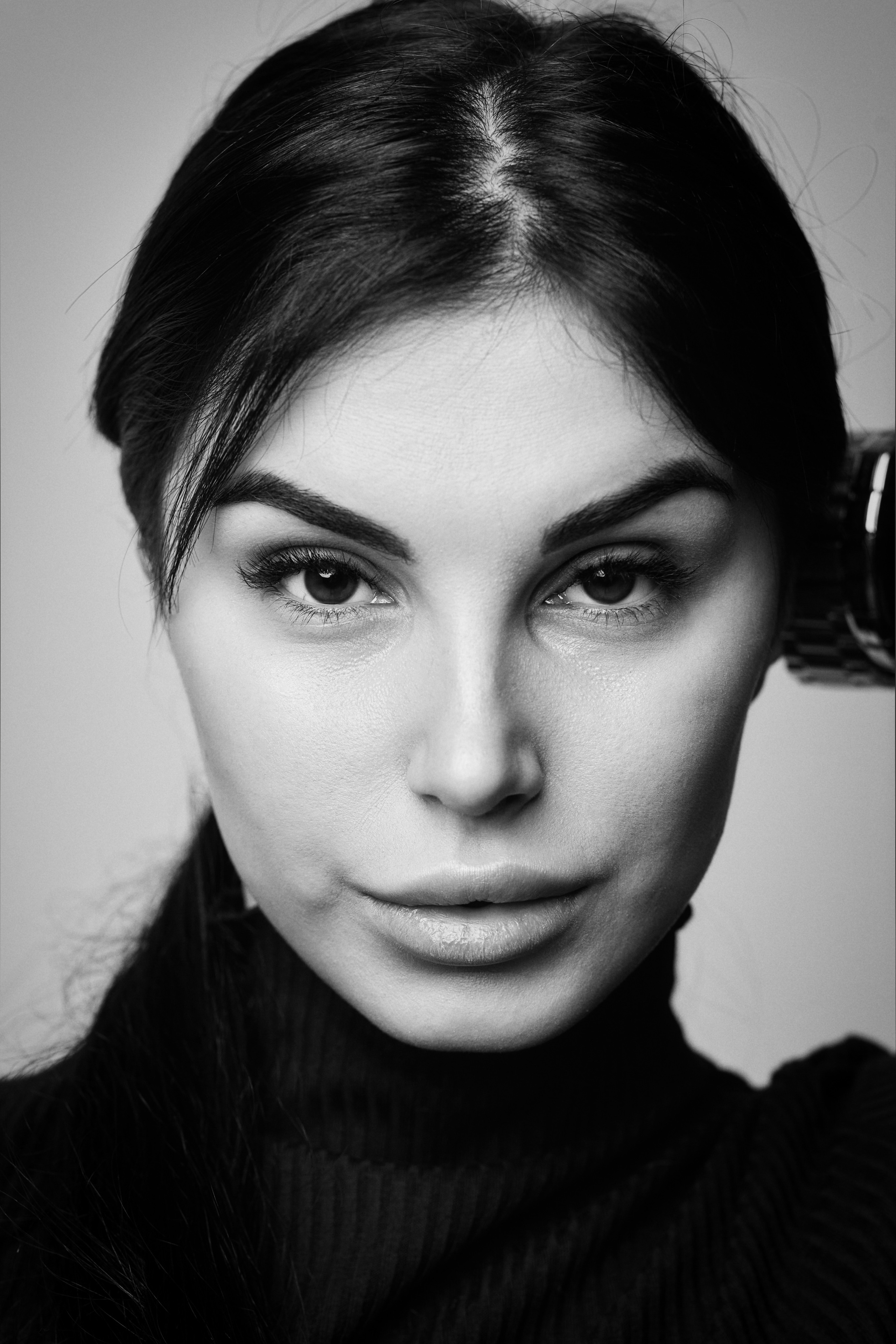 Темноволосая модель Карина в рубашке на светлом фоне студии создает образ активной и целеустремленной женщины.