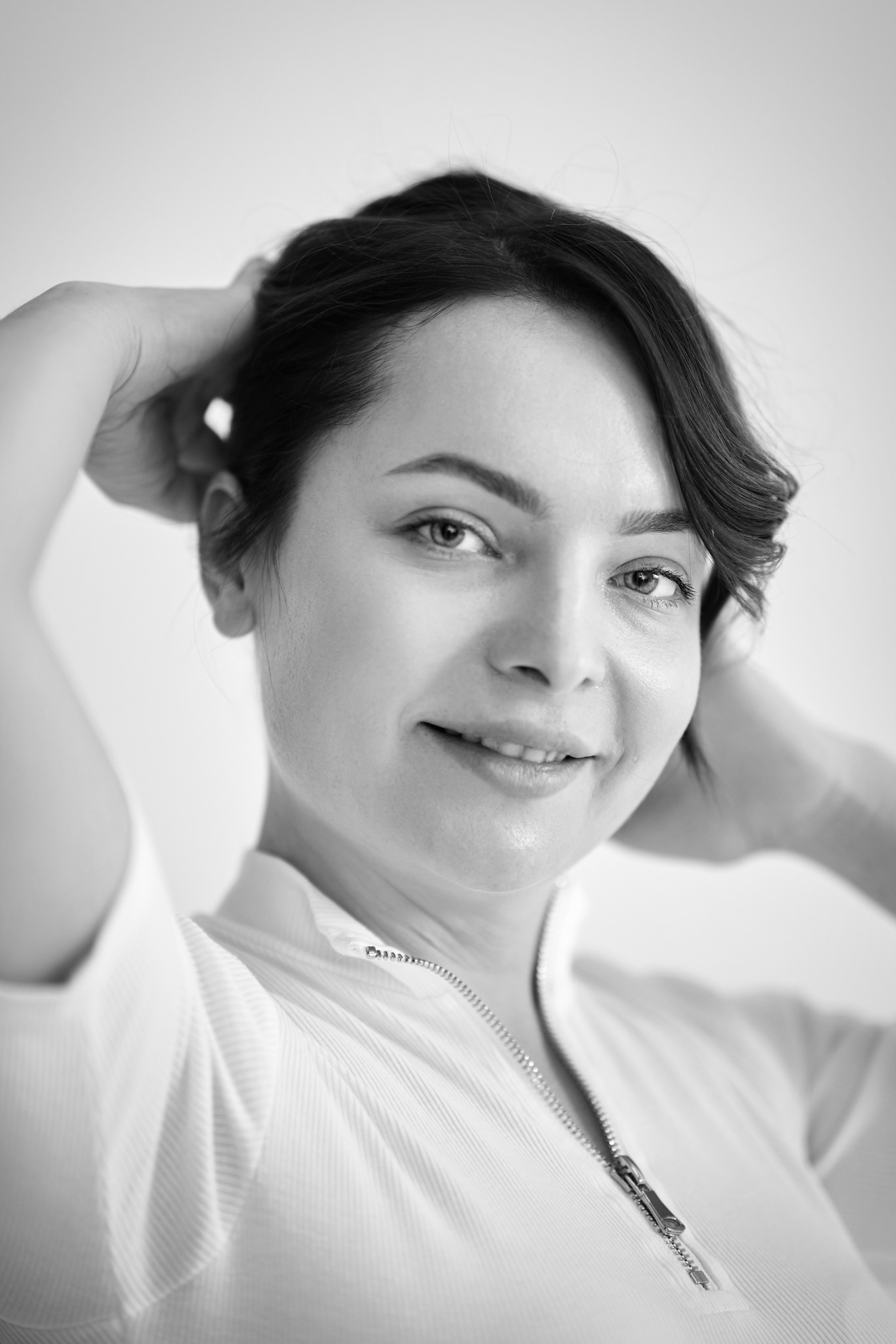 Модель Татьяна в топике стоит в студии на светлом фоне.