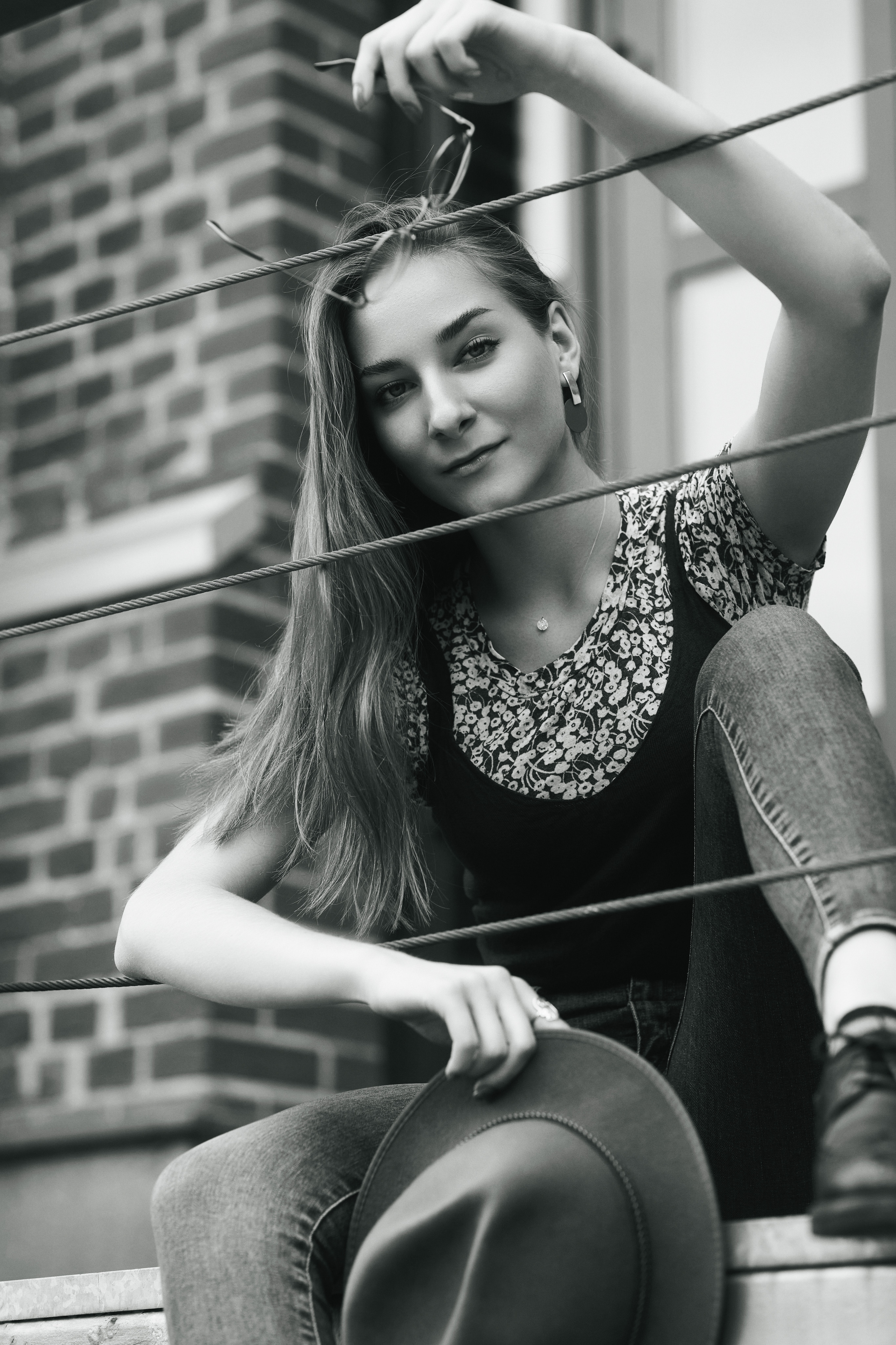 Любовь - модель с длинными волосами, позирующая на улице в элегантном платье или комфортных джинсах.