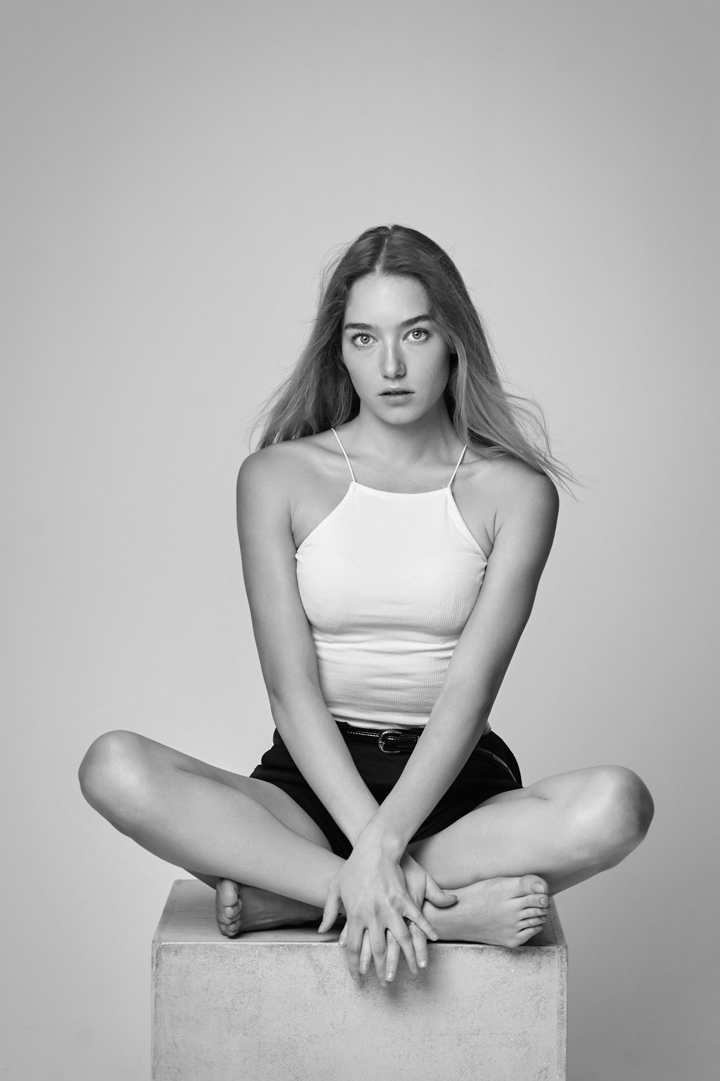 Алиса в черной рубашке на светлом фоне студии - изысканность и элегантность.