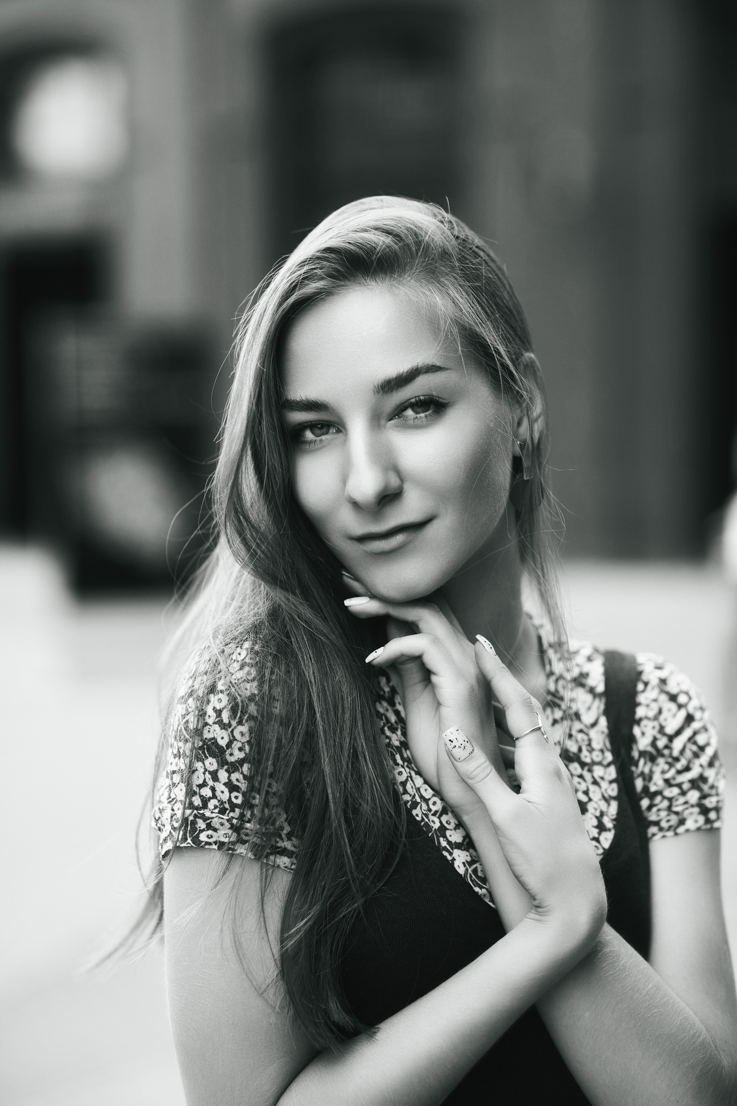 Любовь, темноволосая модель, находится на улице в городе, одетая в стильное платье, которое подчеркивает ее красоту и изящество.