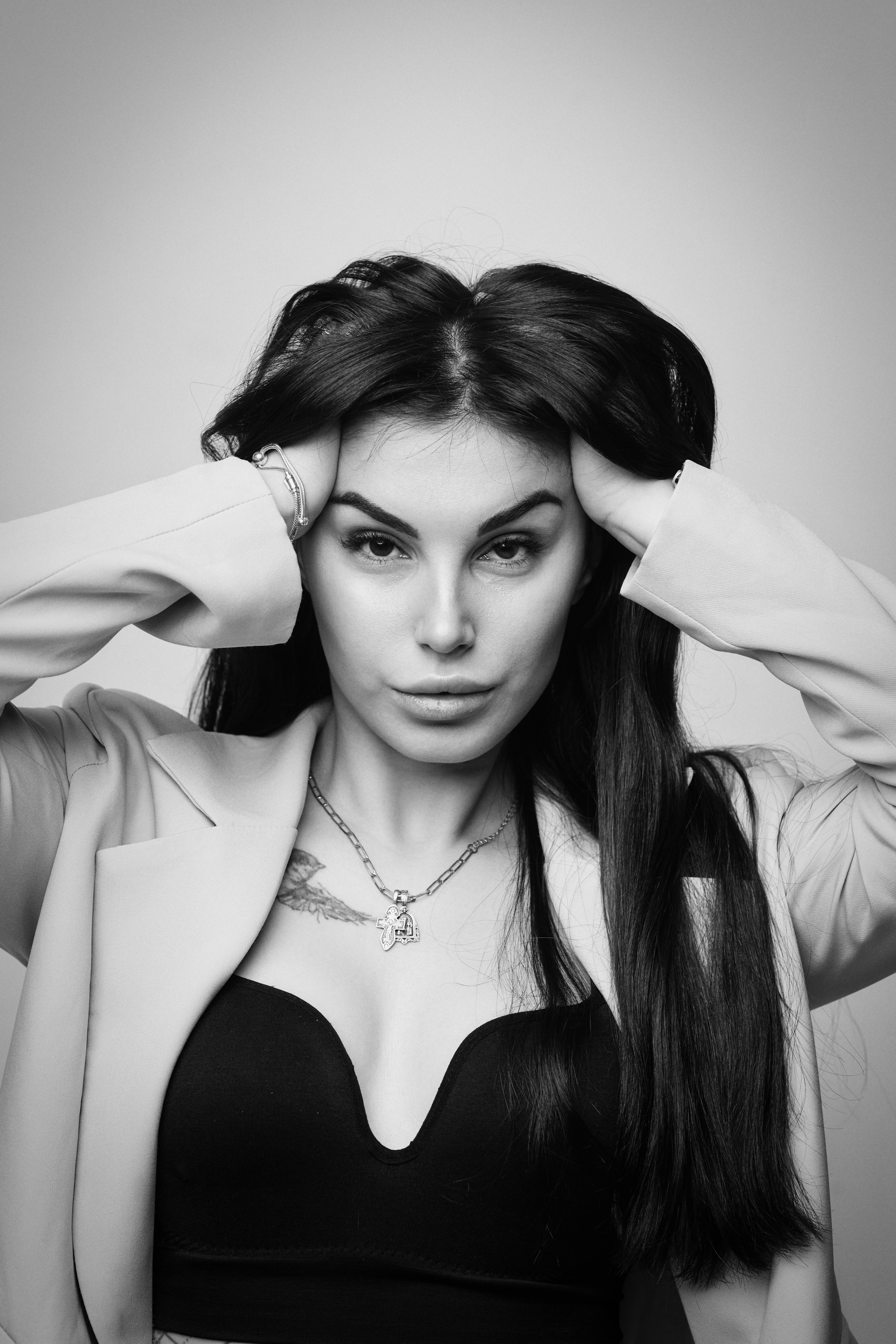 Карина в костюме на светлом фоне: красивая фотосессия в студии