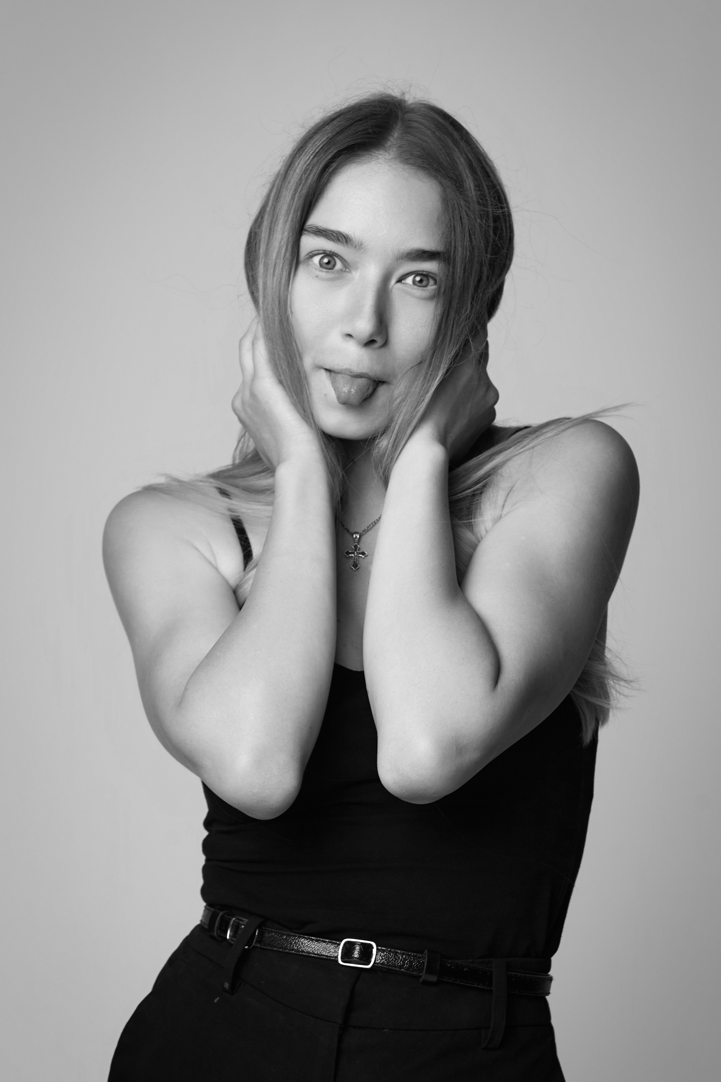 Светловолосая модель Алиса в стильной рубашке фотографируется на светлом фоне студии.