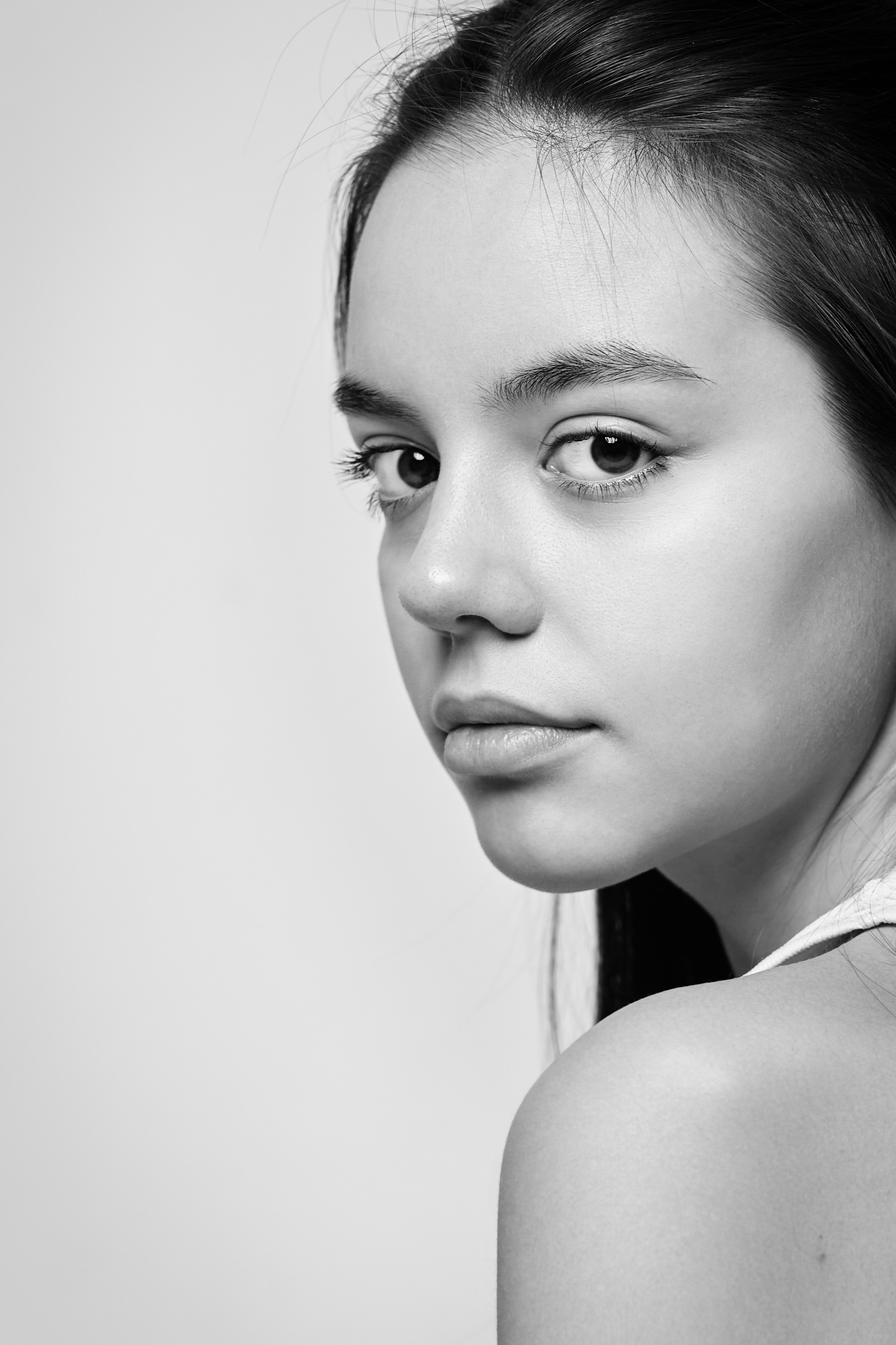 В рубашке на светлом фоне темноволосая модель Амина выглядит привлекательно и элегантно.