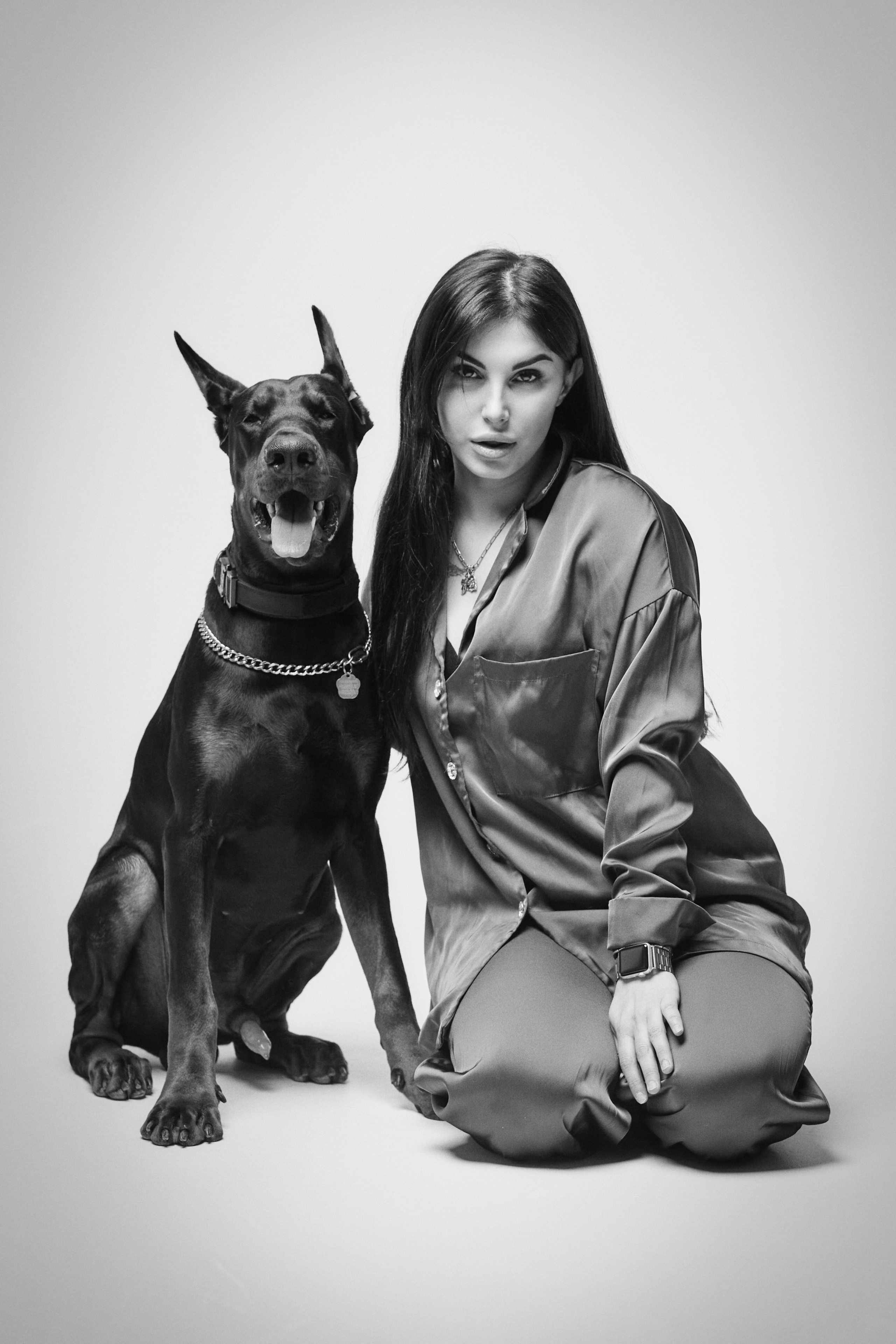 Карина выглядит изумительно в костюме на светлом фоне в студии.