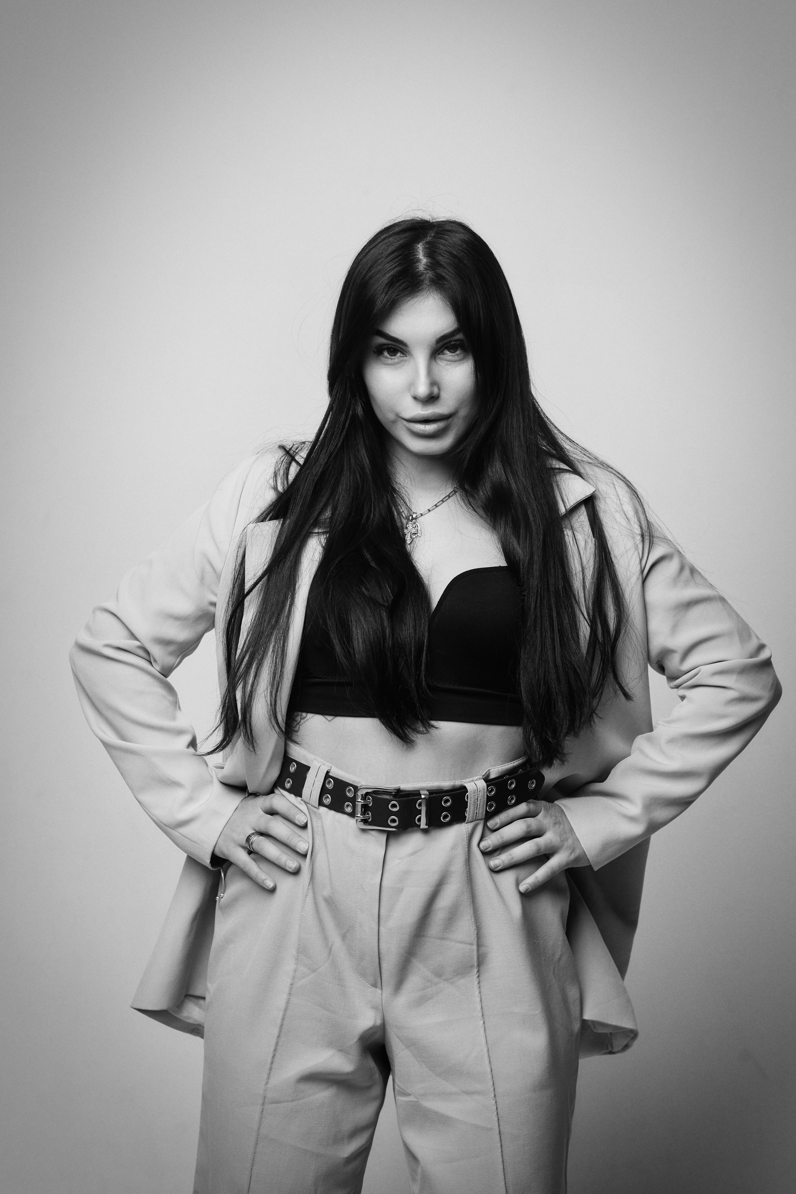 Темноволосая модель Карина в рубашке на светлом фоне, привлекающая внимание.