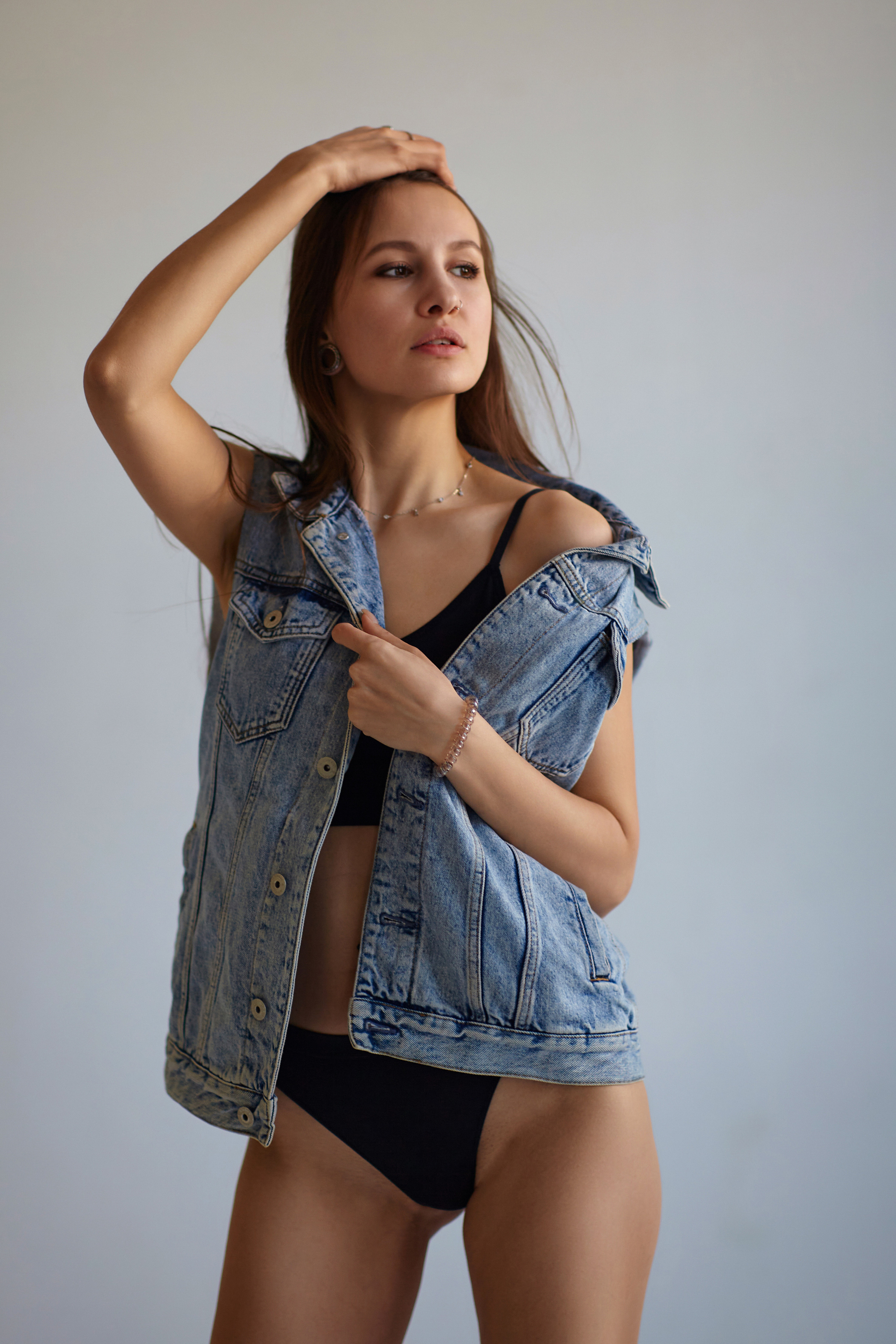 Темноволосая модель на циклораме с светлым фоном в студии готова к фотосесс