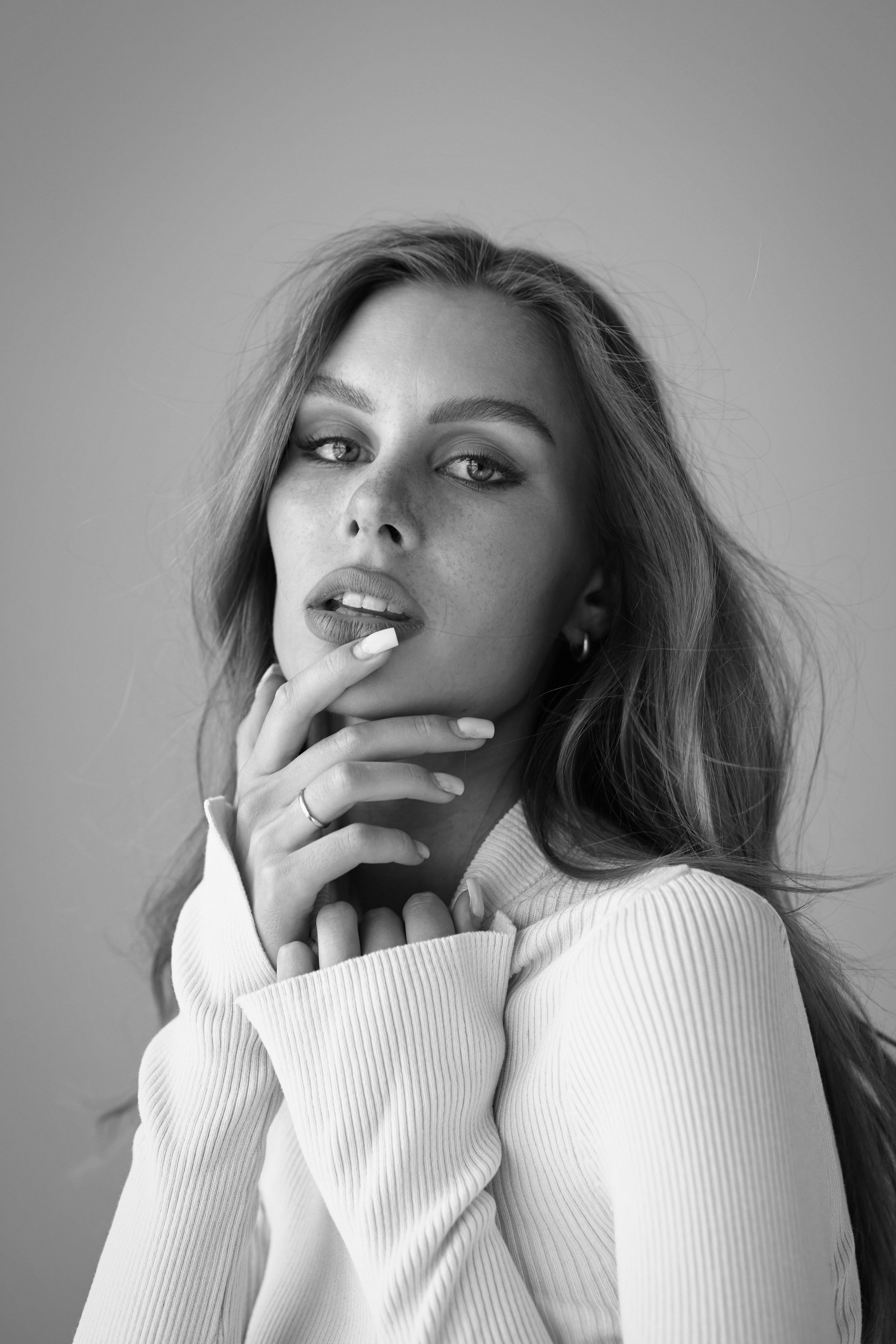 Темноволосая девушка в очках на светлом фоне фотоателье.