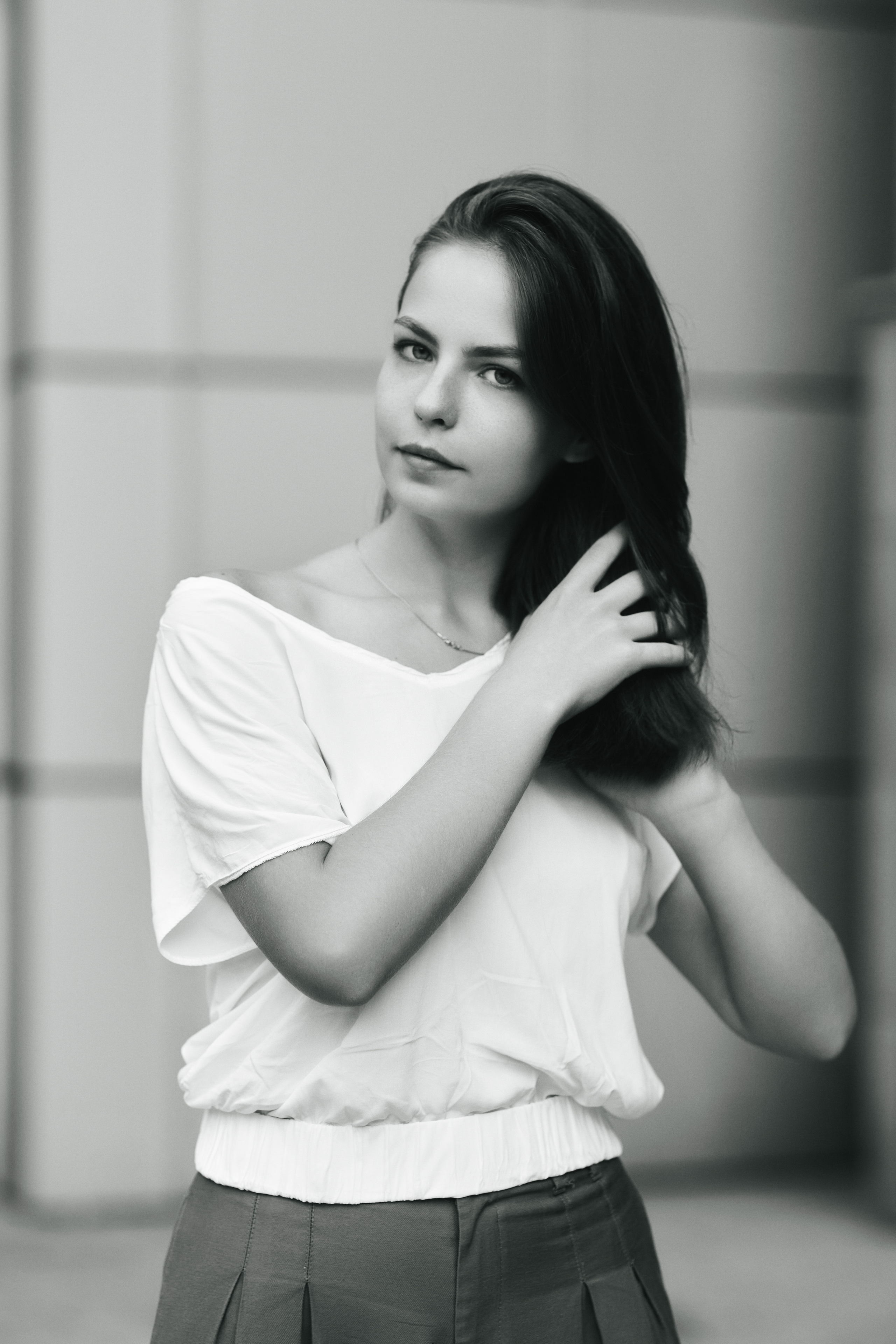 Темноволосая модель Дарья на улице Москвы в светлой кофте и широких брюках.