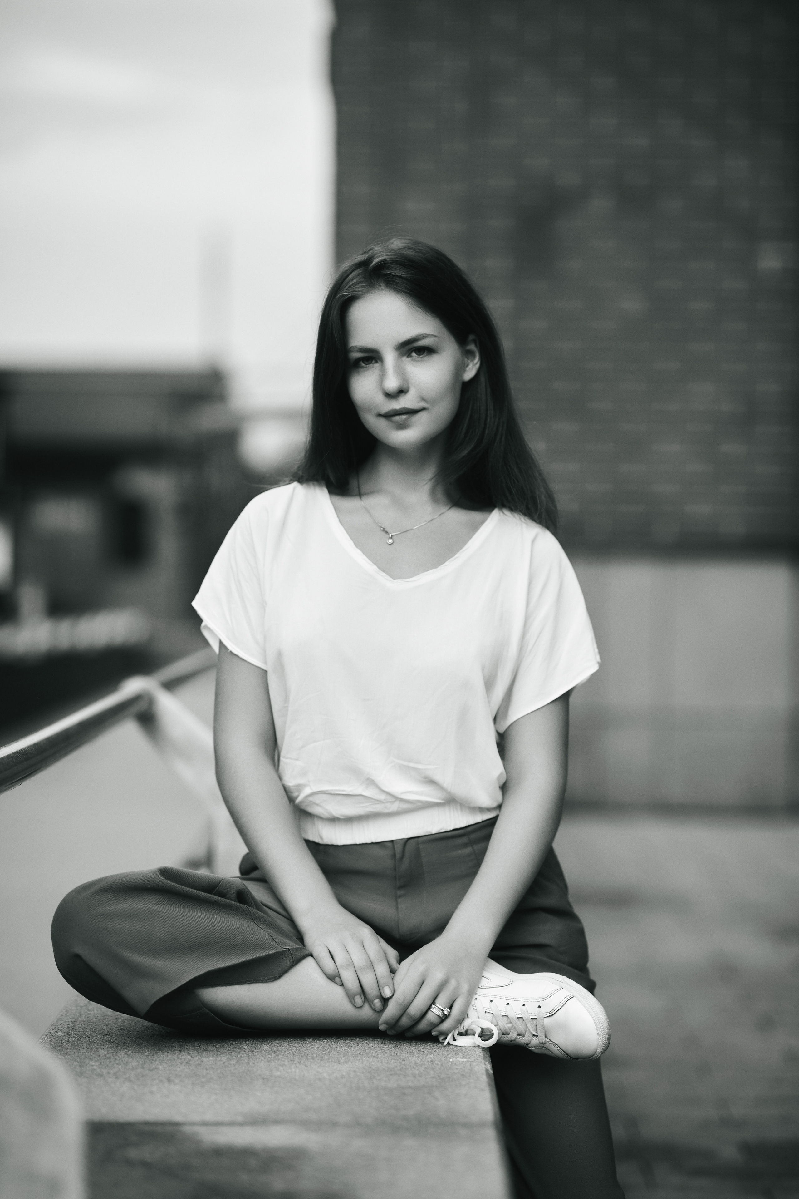 Темноволосая красавица Дарья на улице Москвы в светло-серой кофте и широких брюках.