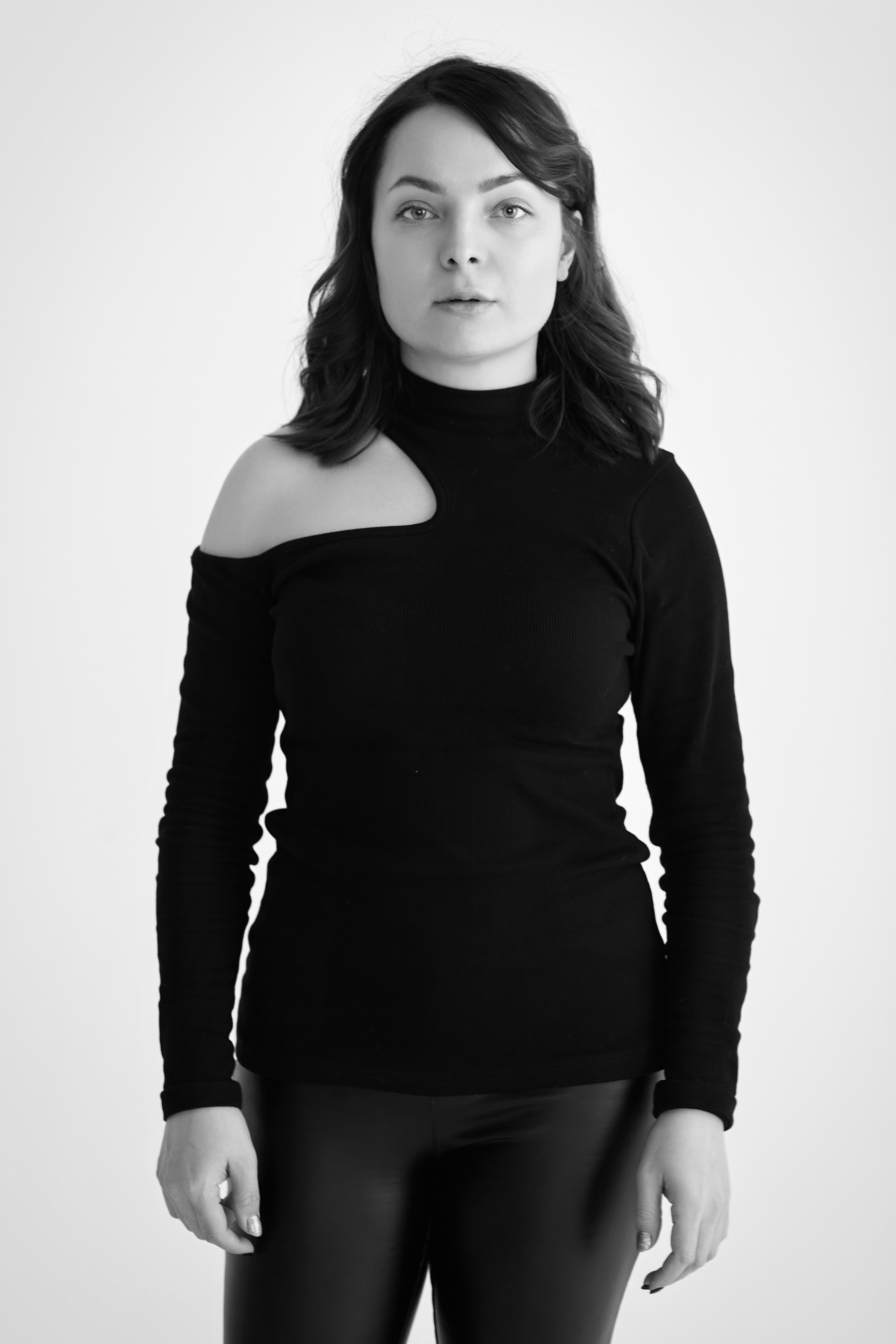 Снимок темноволосой модели Татьяны на светлом фоне, в светлом платье, рубашке или топике или на стуле, с естественной позой.