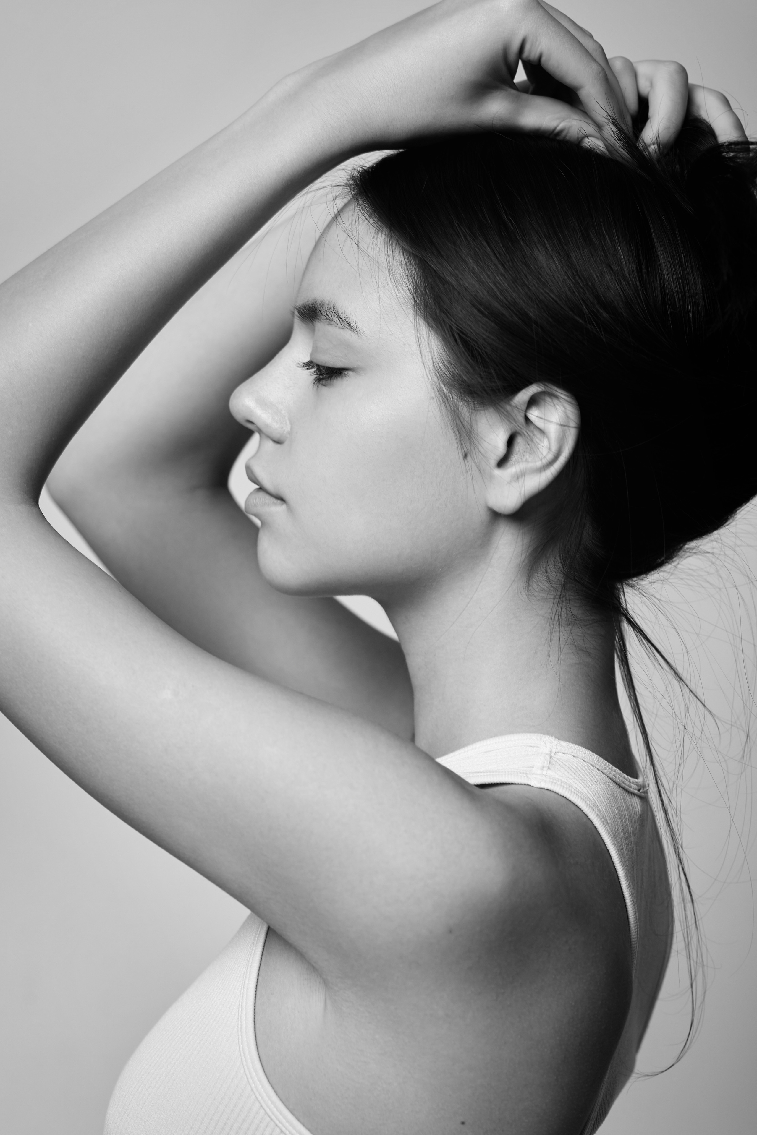 Темноволосая Амина в студии на светлом фоне одета в топик, ее глаза притягивают внимание.