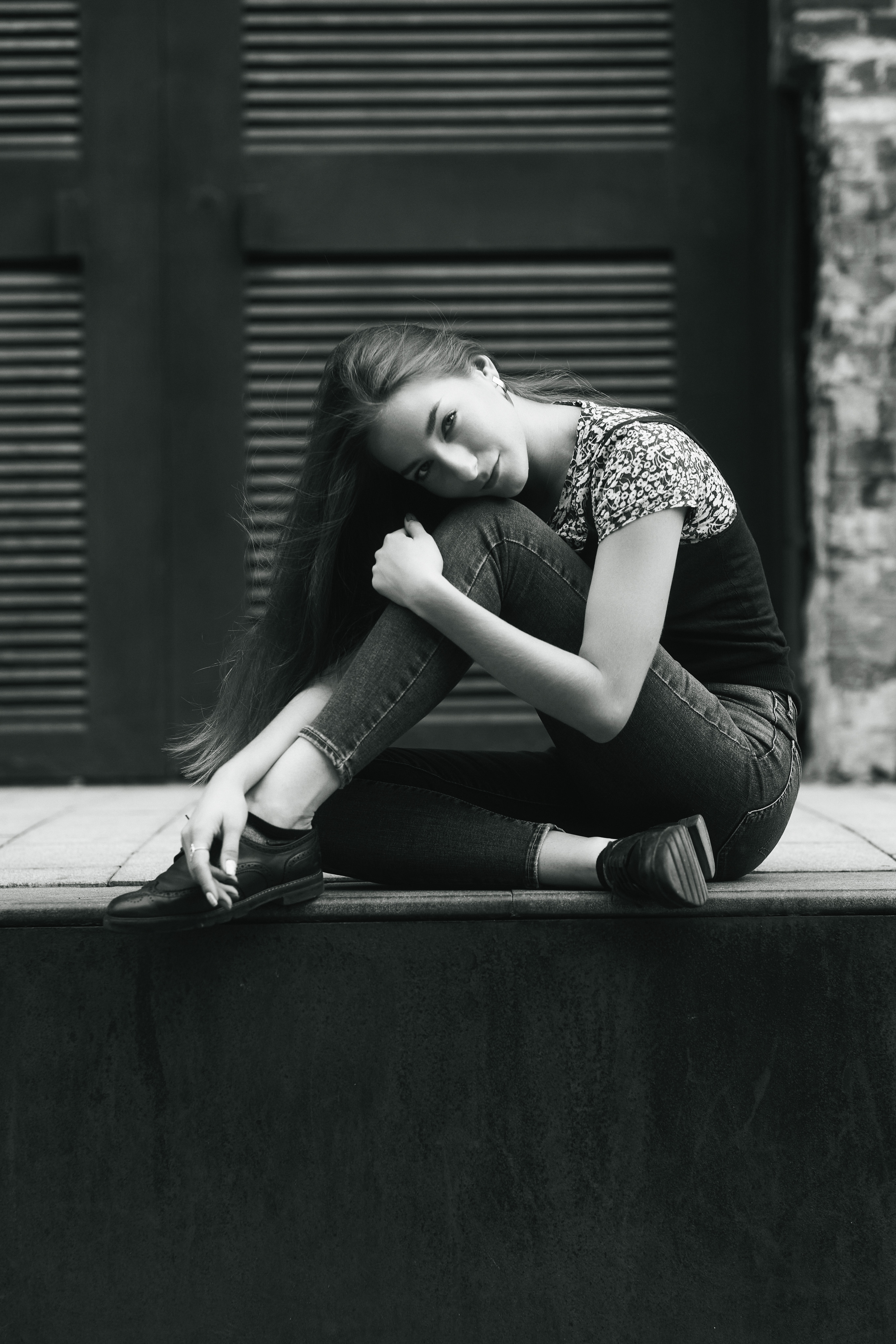 Модель Любовь, красотка с темными волосами, на улице в городе в платье или джинсах.