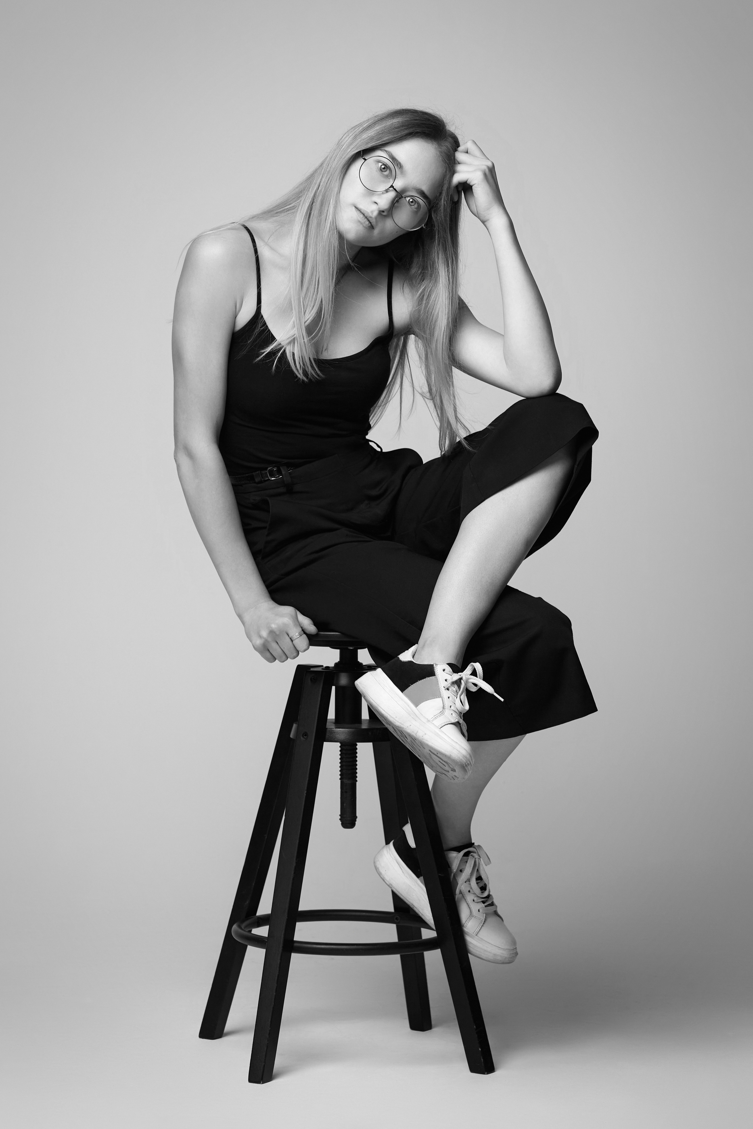 Светловолосая модель Алиса в студии на светлом фоне, одетая в красное платье, подчеркивающее ее фигуру.