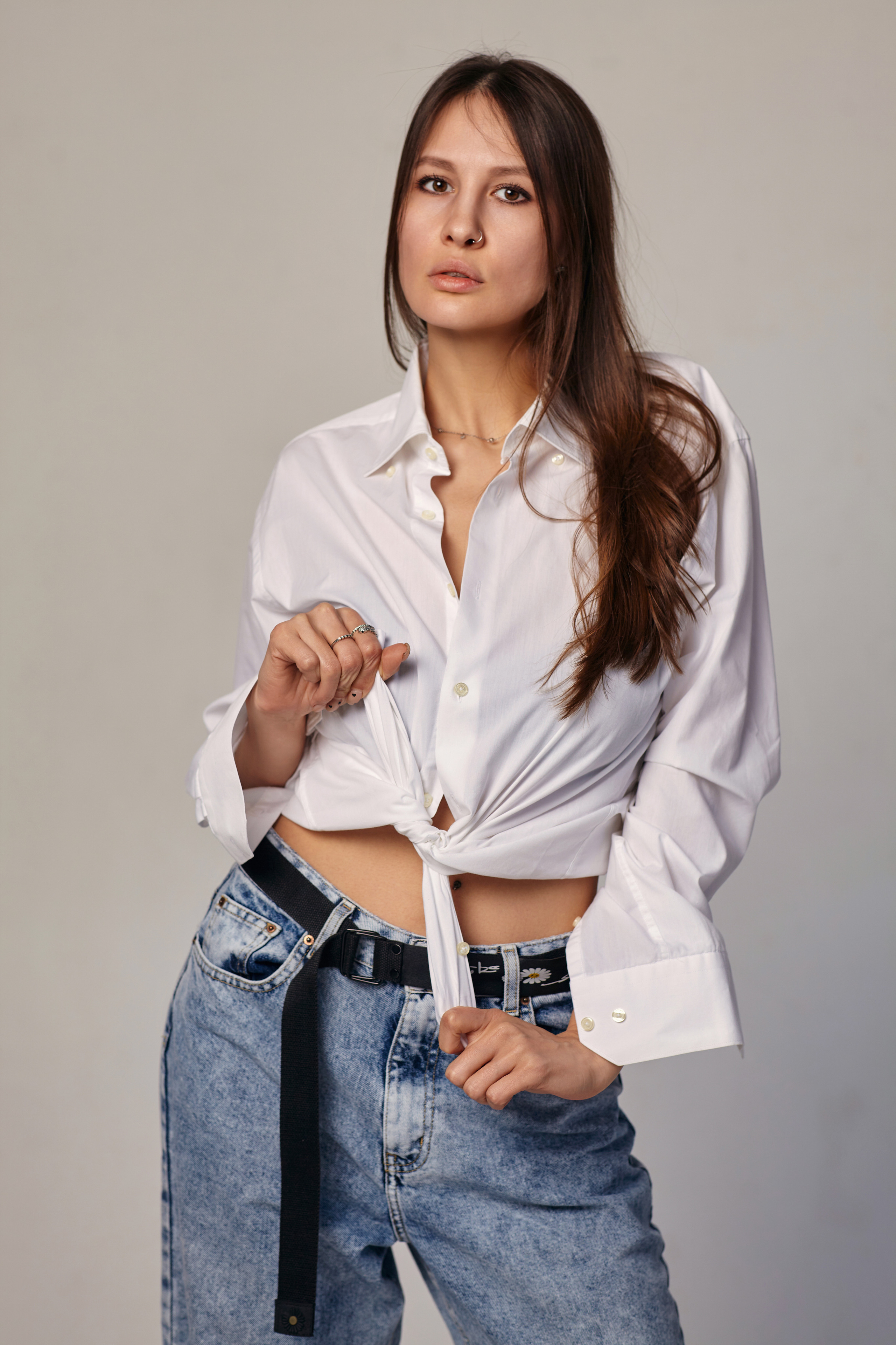 Красивая девушка на светлом фоне в студии с темными волосами и ярким макияжем