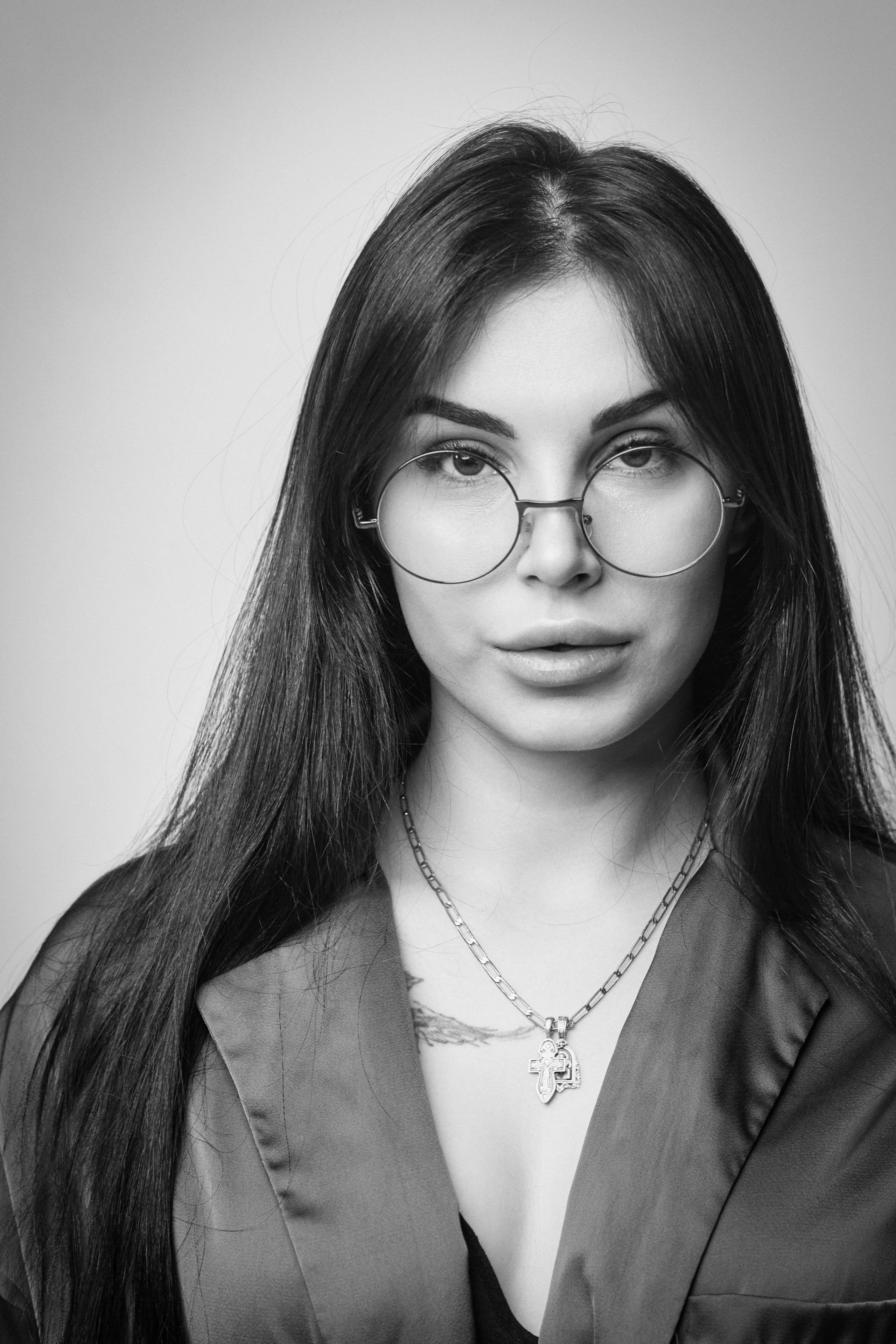 В костюме на светлом фоне студии темноволосая Карина выглядит деловой и уверенной в своих силах.