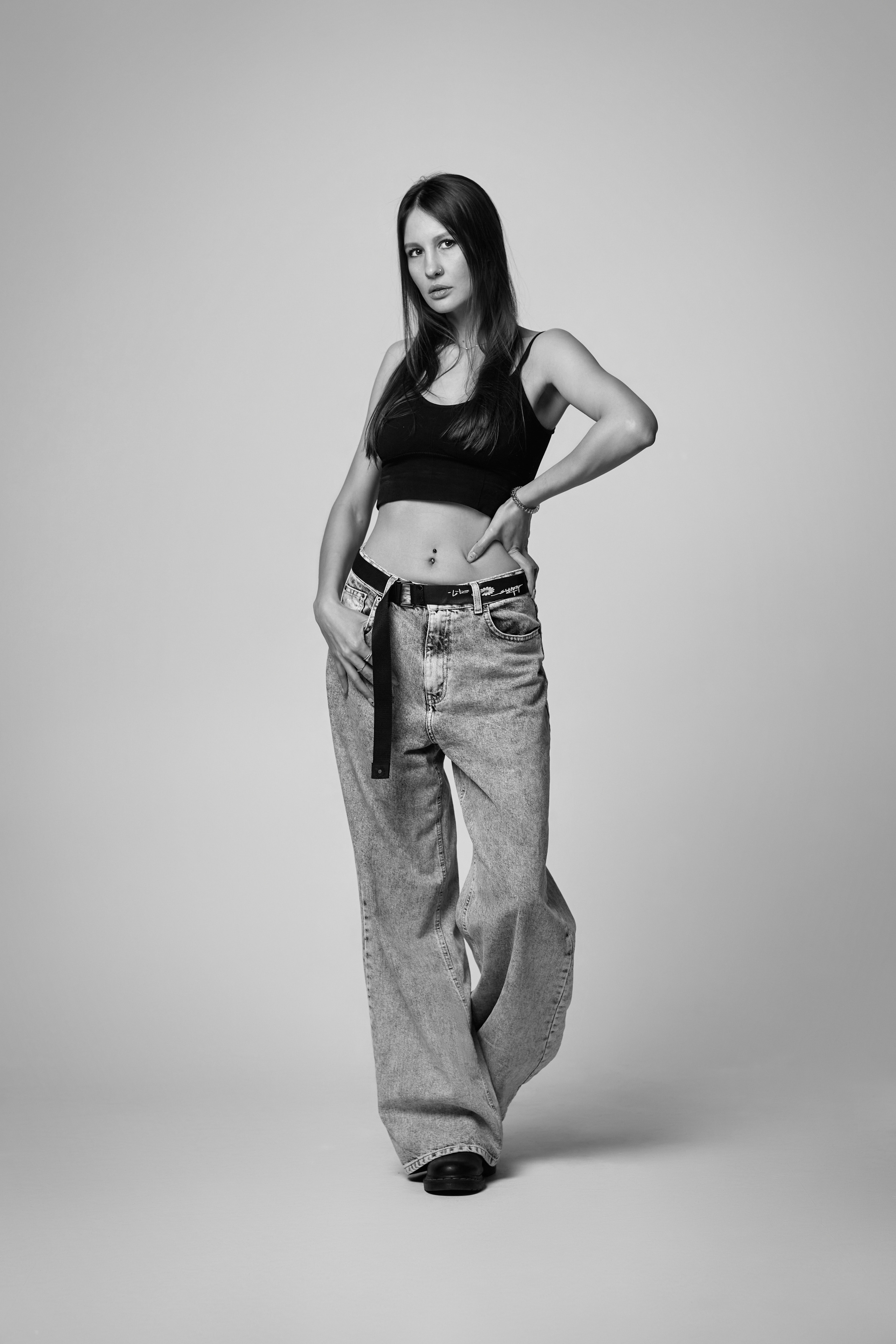 Красивая девушка с темными волосами в фотостудии на светлом фоне