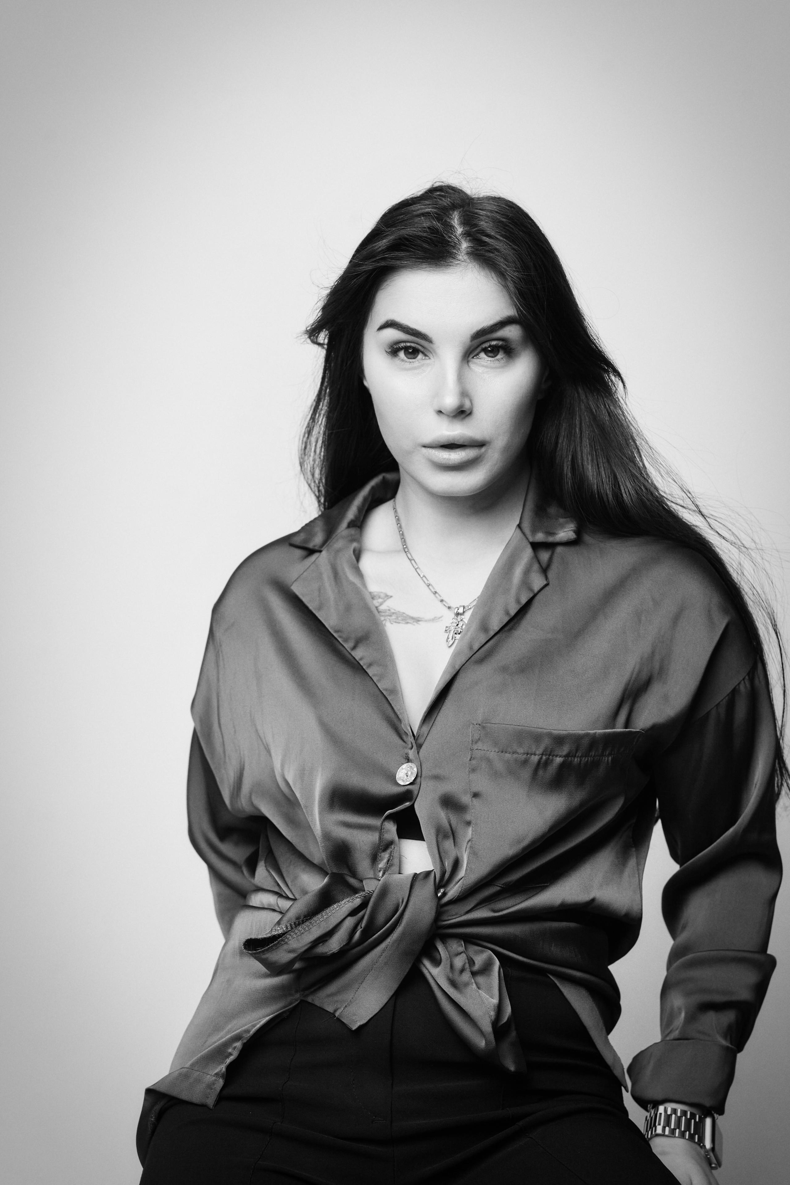 Карина в студии на светлом фоне в рубашке и юбке, классический и стильный образ