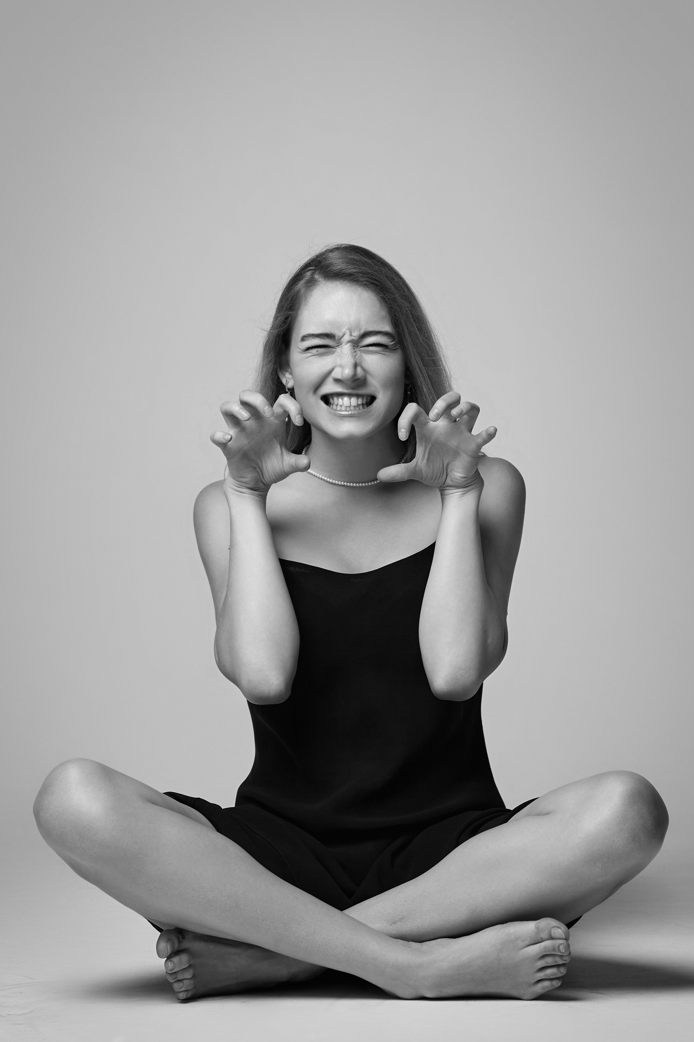 Снимки Алисы в студии на светлом фоне в блестящем платье и высоких каблуках.