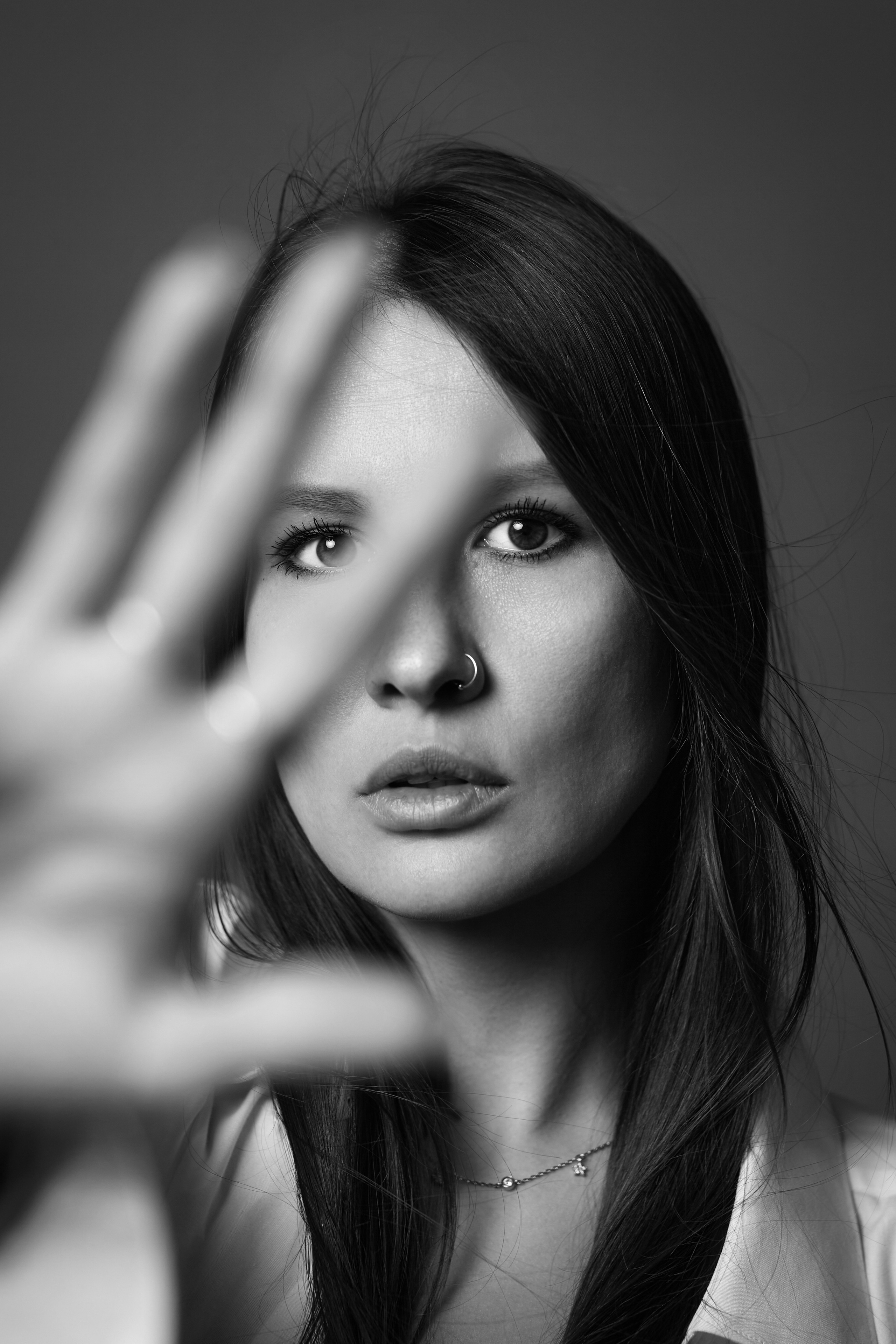 Темноволосая красотка на тёмной циклораме в студии.