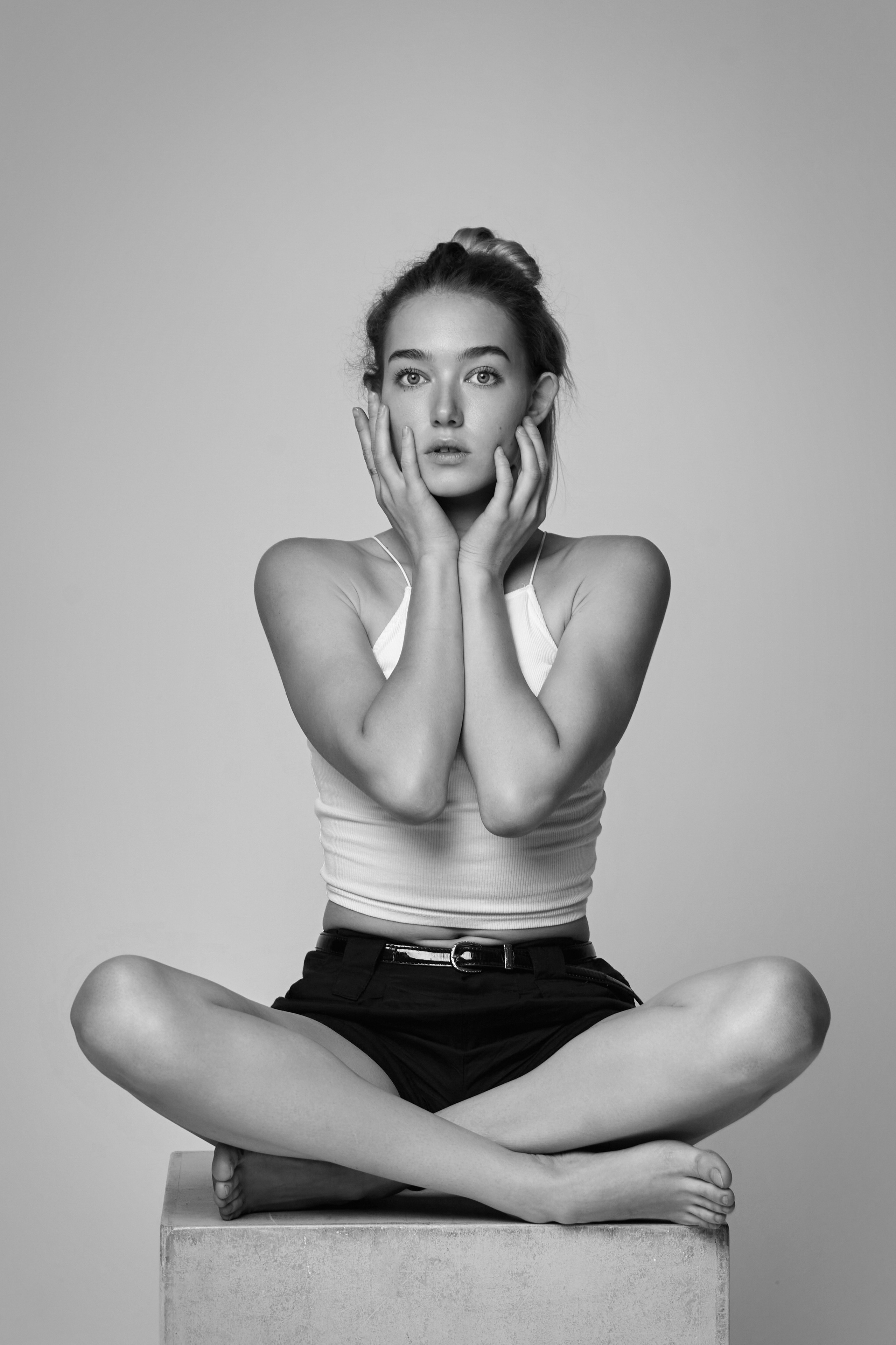 Нежная и изящная Алиса в светлом платье на фоне светлой стены в студии.