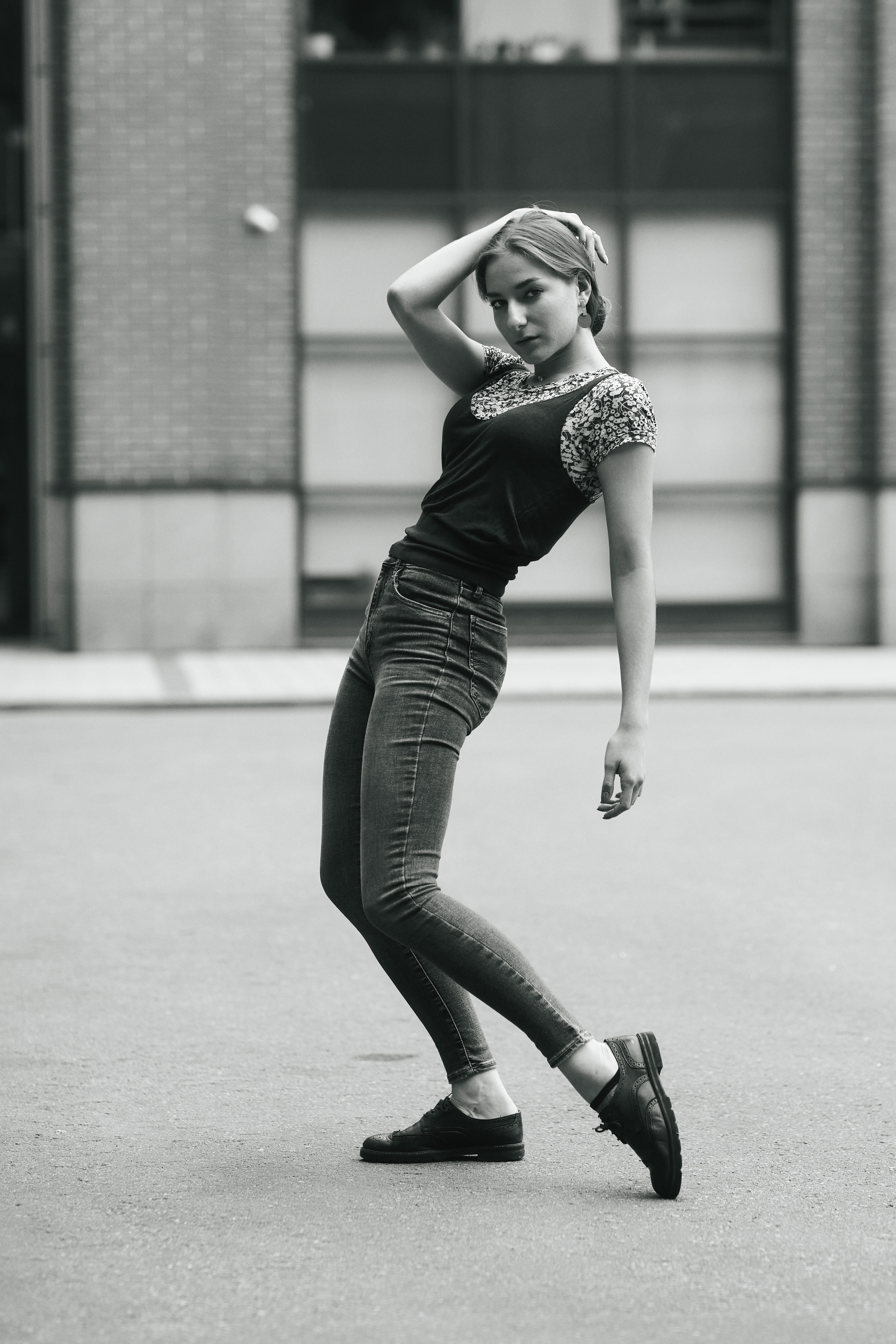 Модель Любовь, позирующая на улицах города в изящном платье или джинсах.