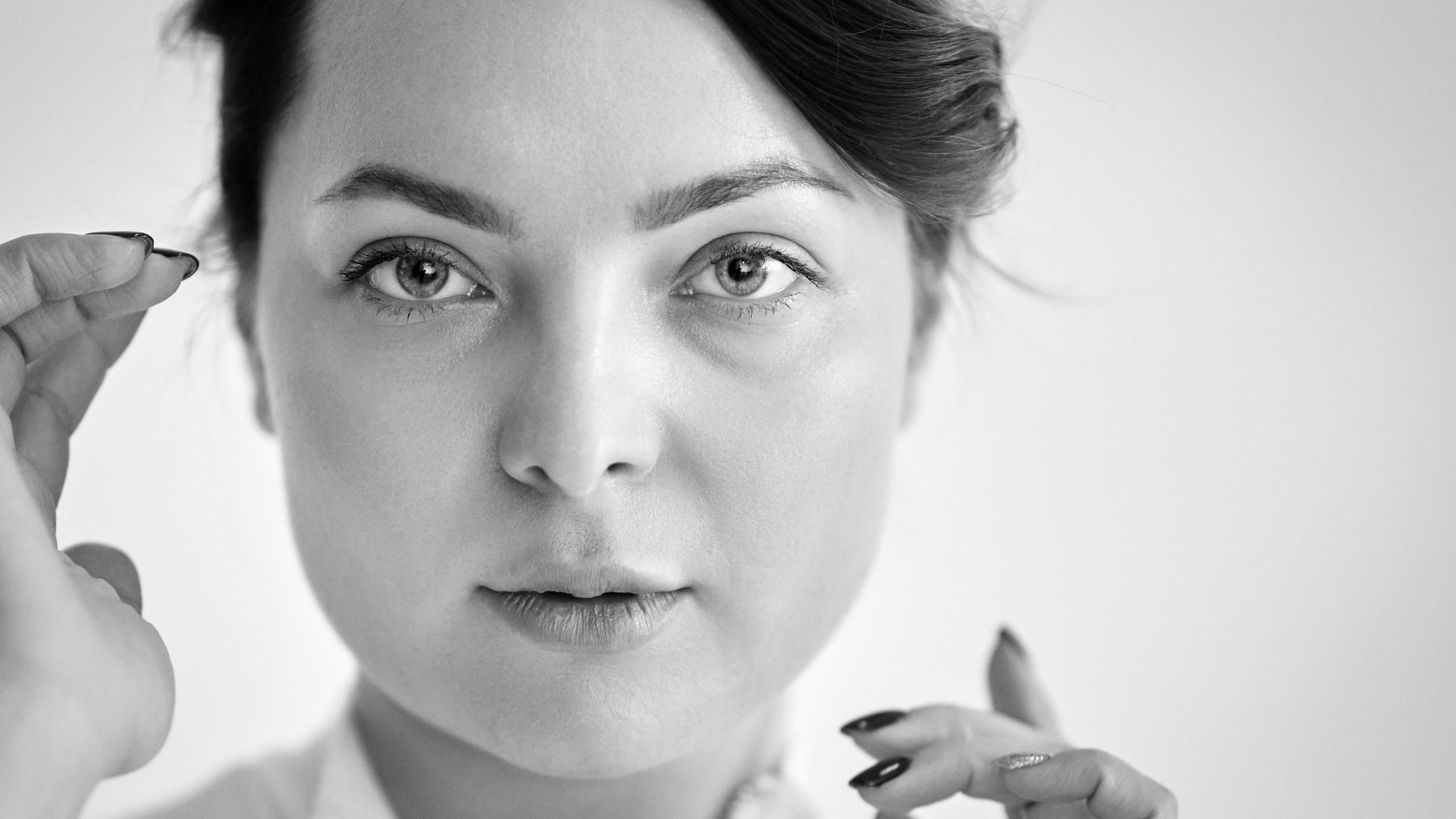 Студийный снимок темноволосой модели Татьяны на светлом фоне в светлом платье, рубашке или топике, находящейся на стуле.