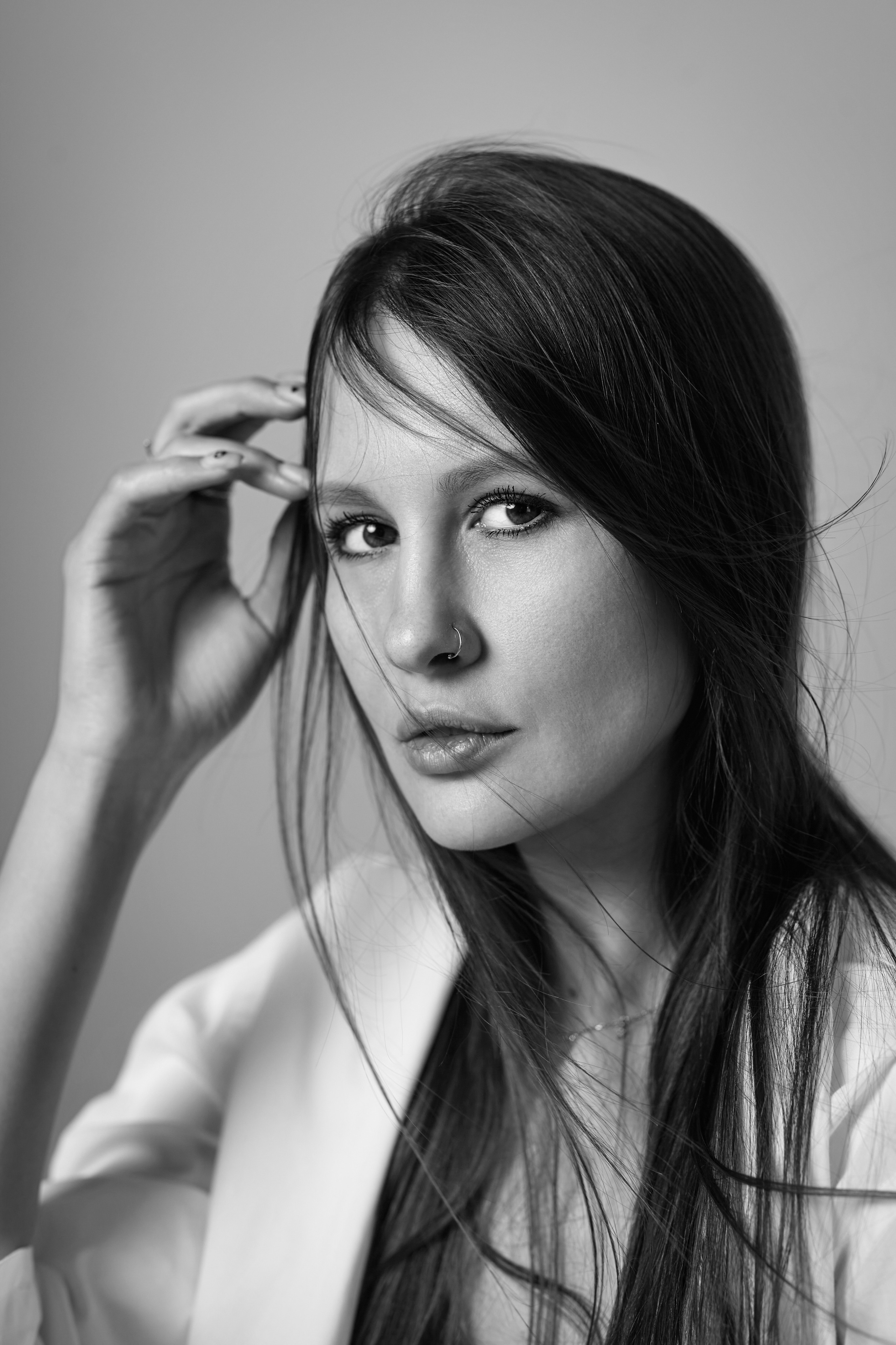 Темноволосая девушка на светлом циклорамном фоне.