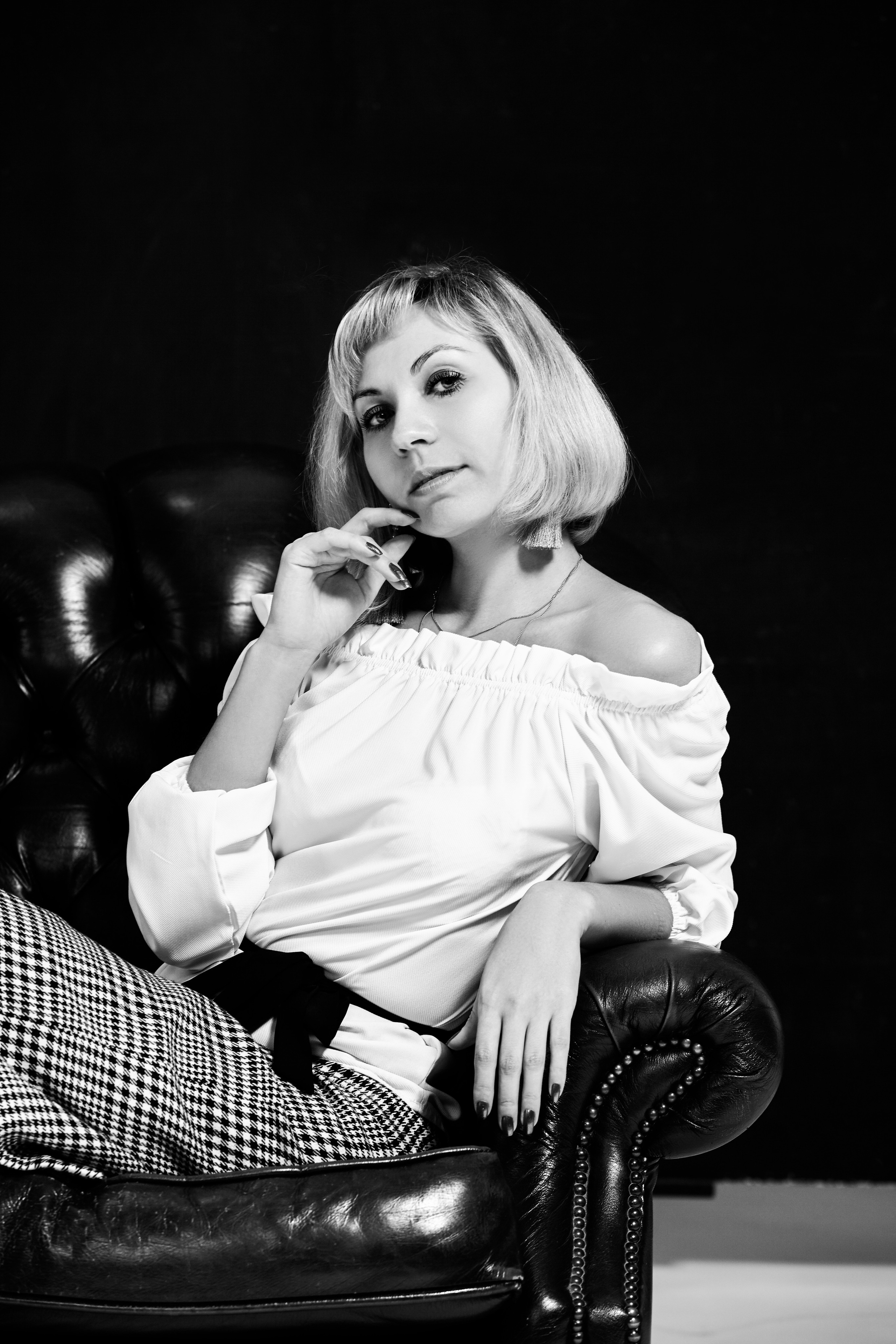 Светловолосая Анастасия в платье на фоне темной студии