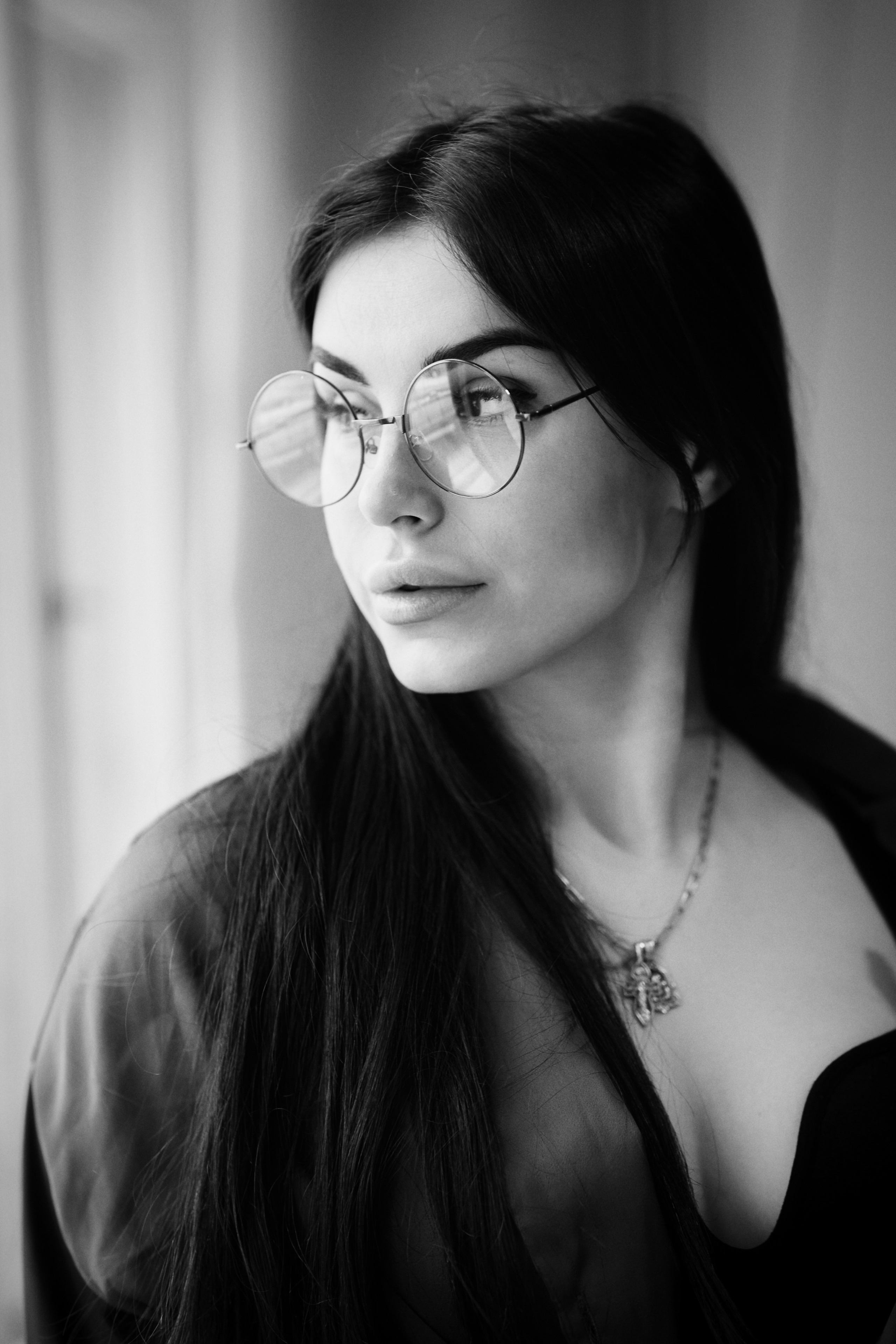 Темноволосая модель Карина в стильном костюме на светлом фоне в студии.