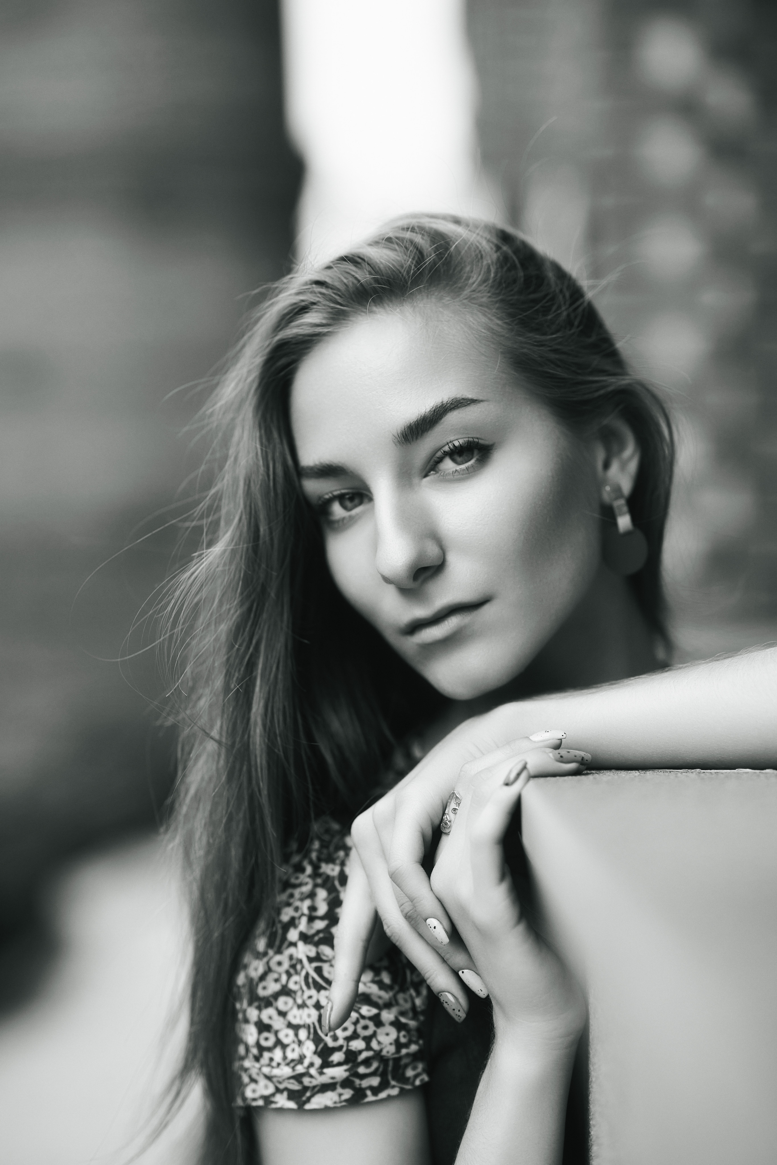 Темноволосая красавица Любовь на фоне городской среды, одетая в платье или джинсы.