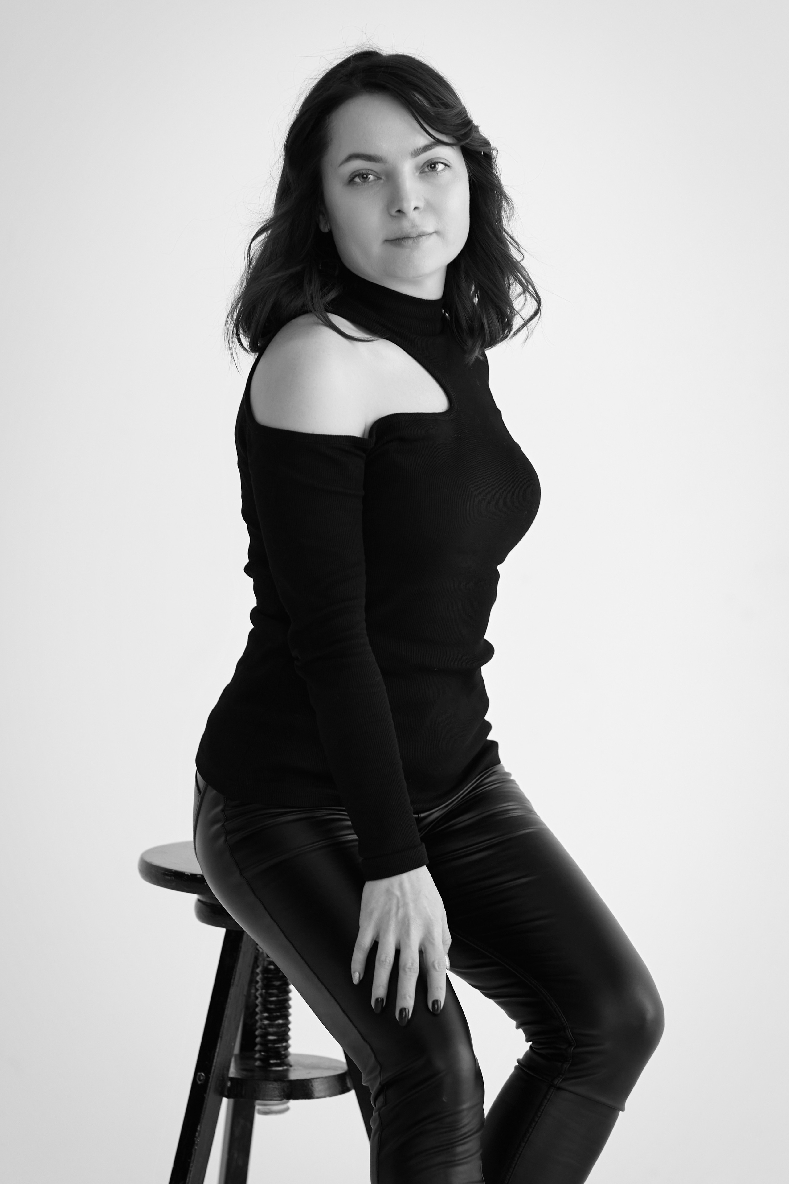 Красотка Татьяна на стуле в студии, одетая в светлое платье или топик.