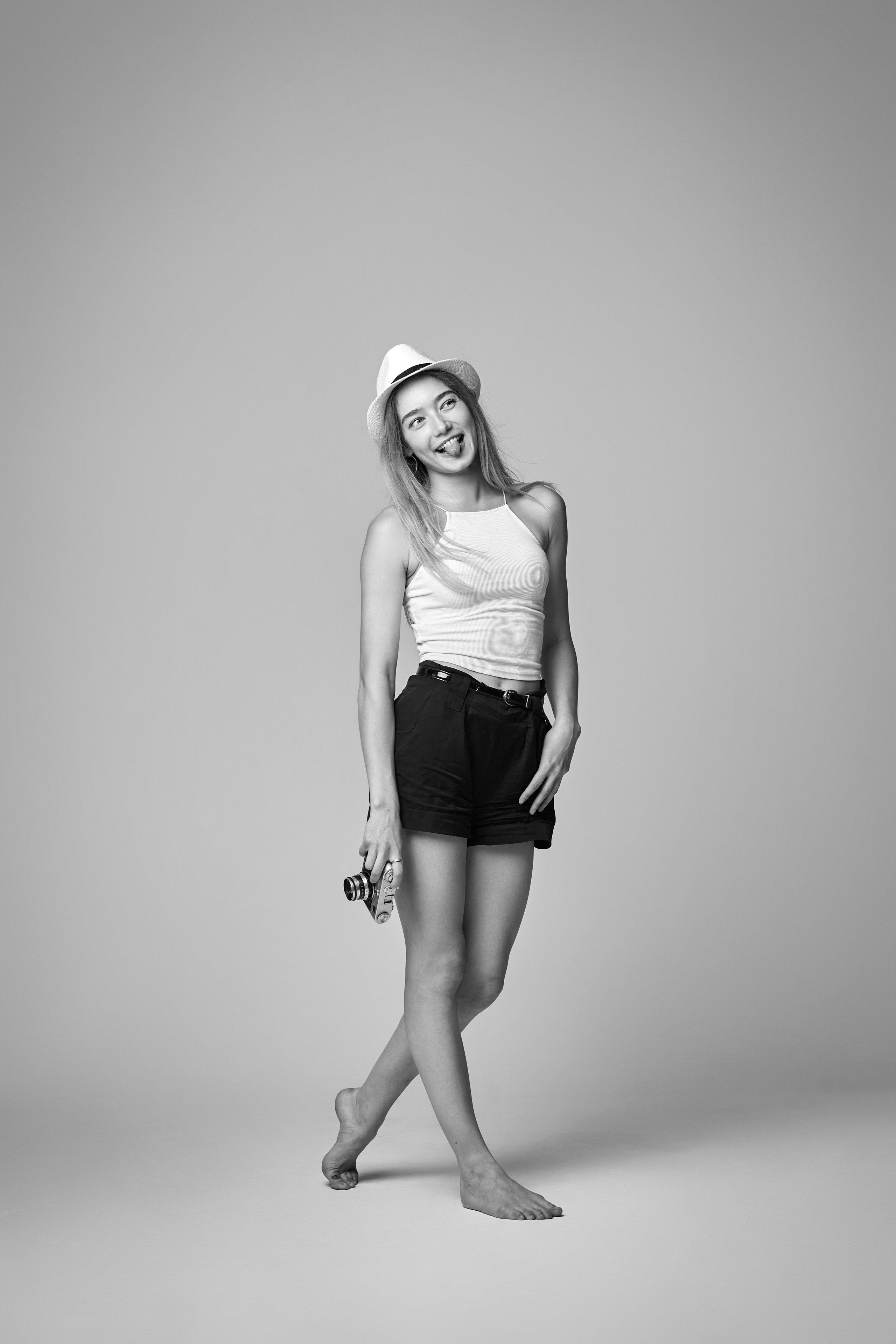 Стильная модель Алиса в рубашке на фоне светлой стены в фотостудии.