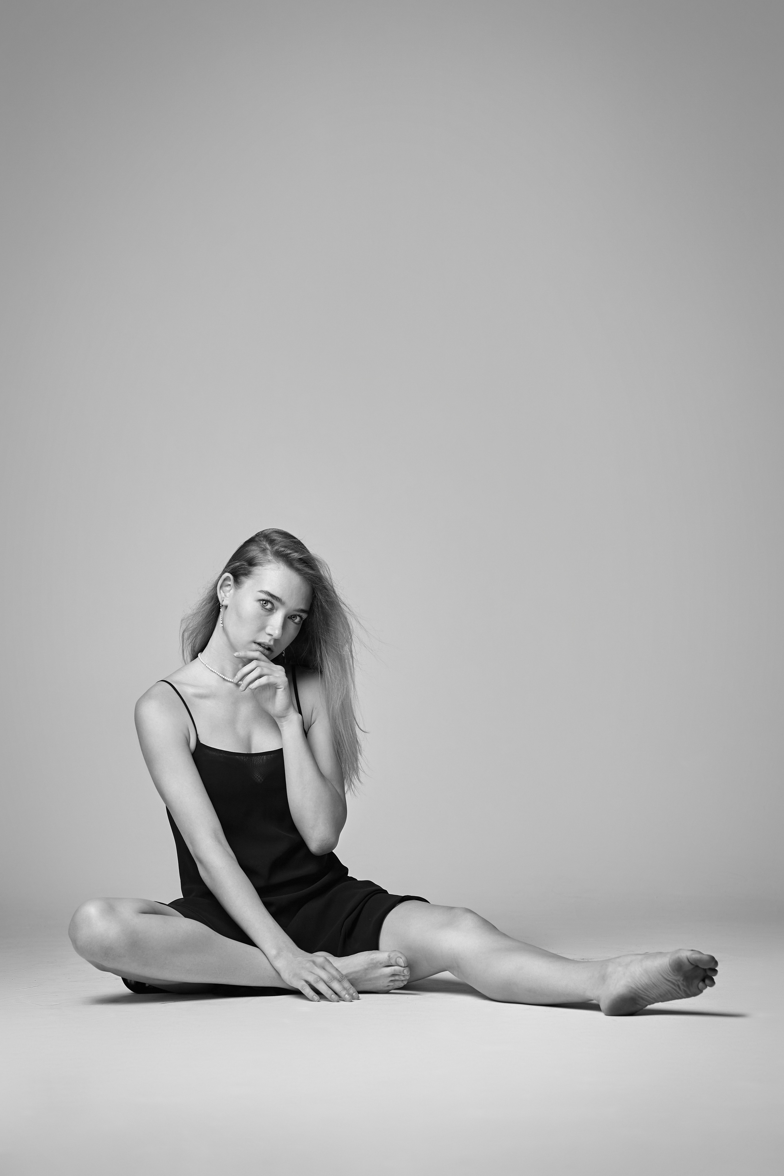 Светловолосая модель Алиса в студии на светлом фоне в розовом платье-миди с расклешенной юбкой.