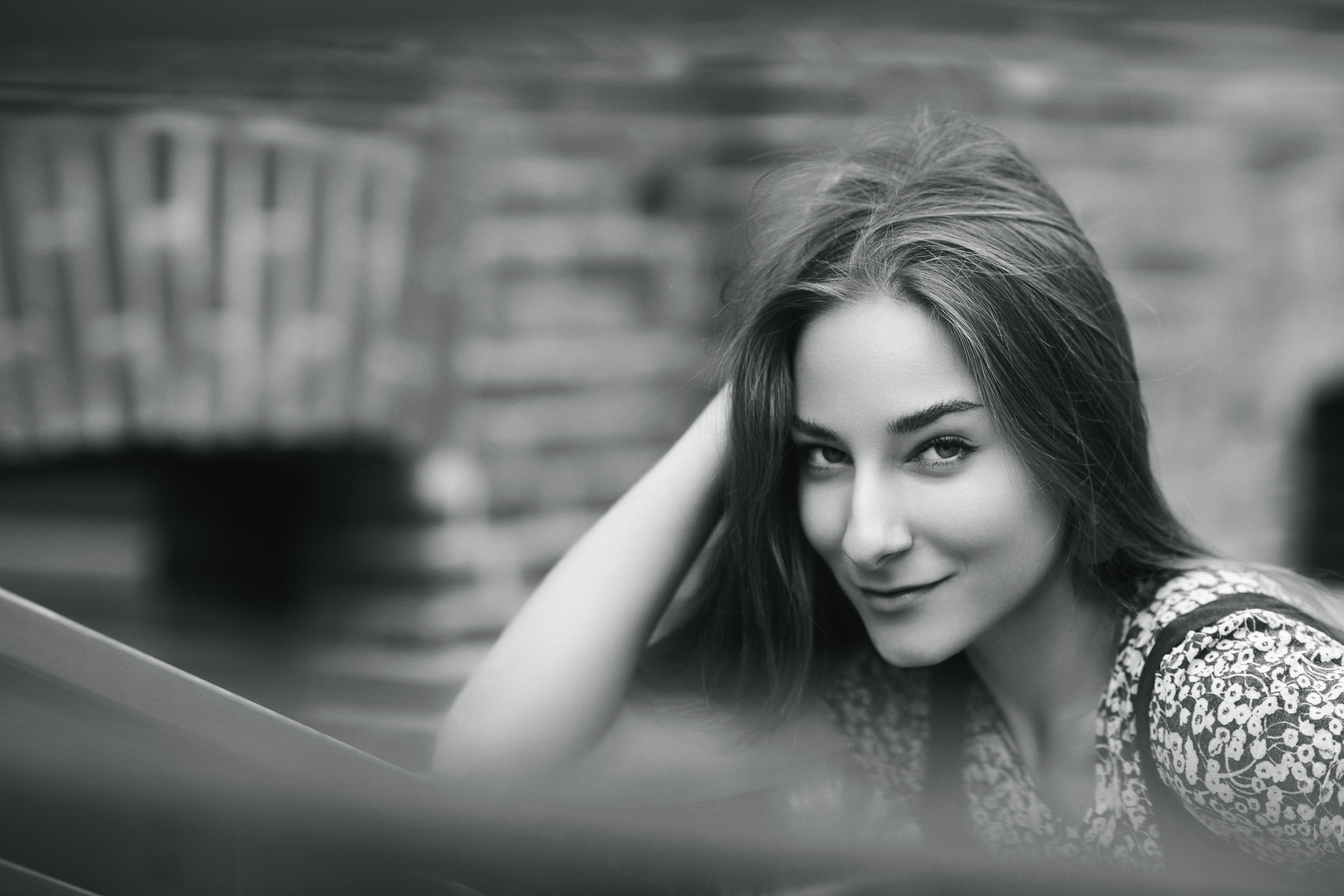 Темноволосая красавица Любовь на улице в городе в платье, которое придает ей шарм и чувственность.