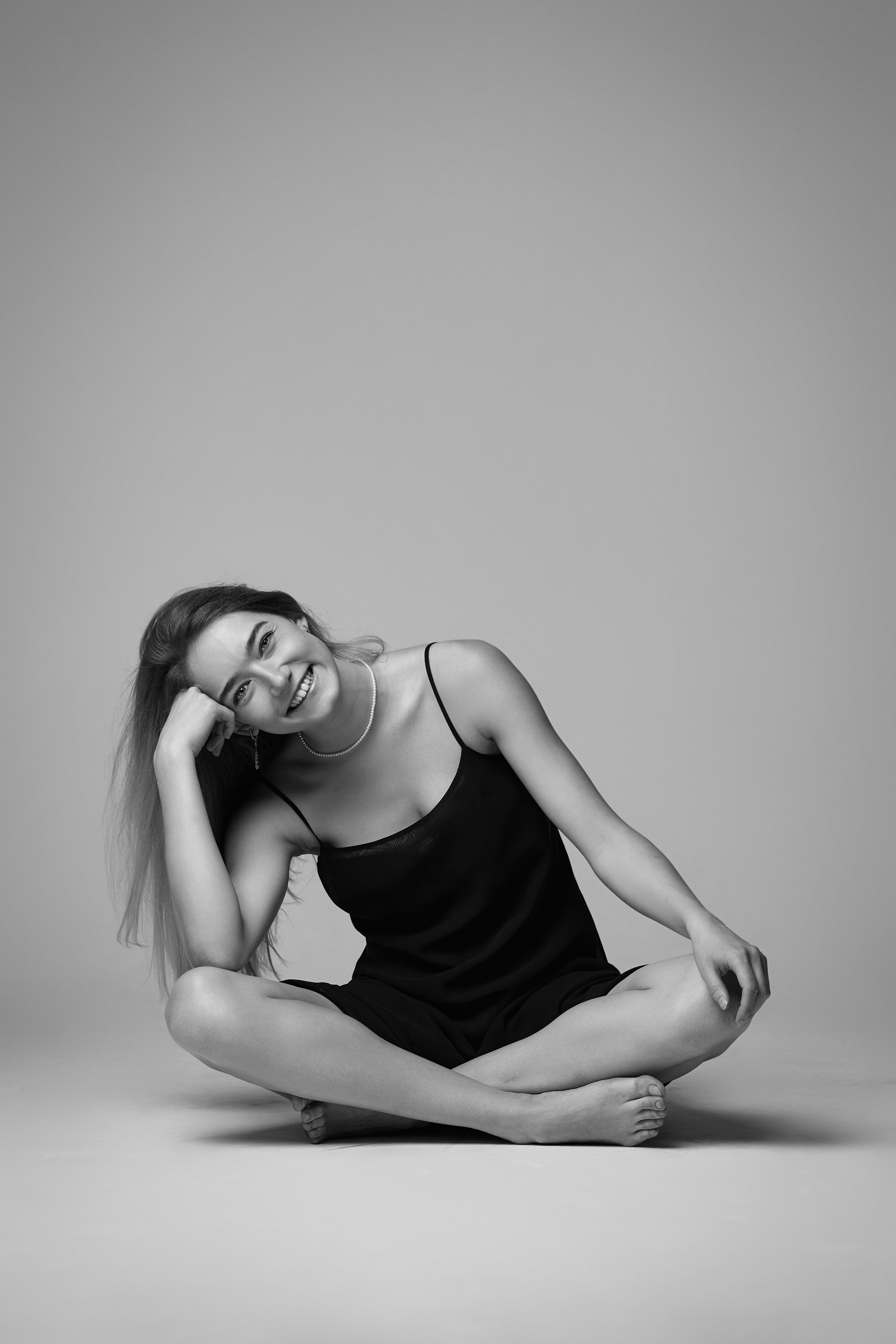 Нежная светловолосая модель Алиса в шелковистом платье на светлом фоне студии.