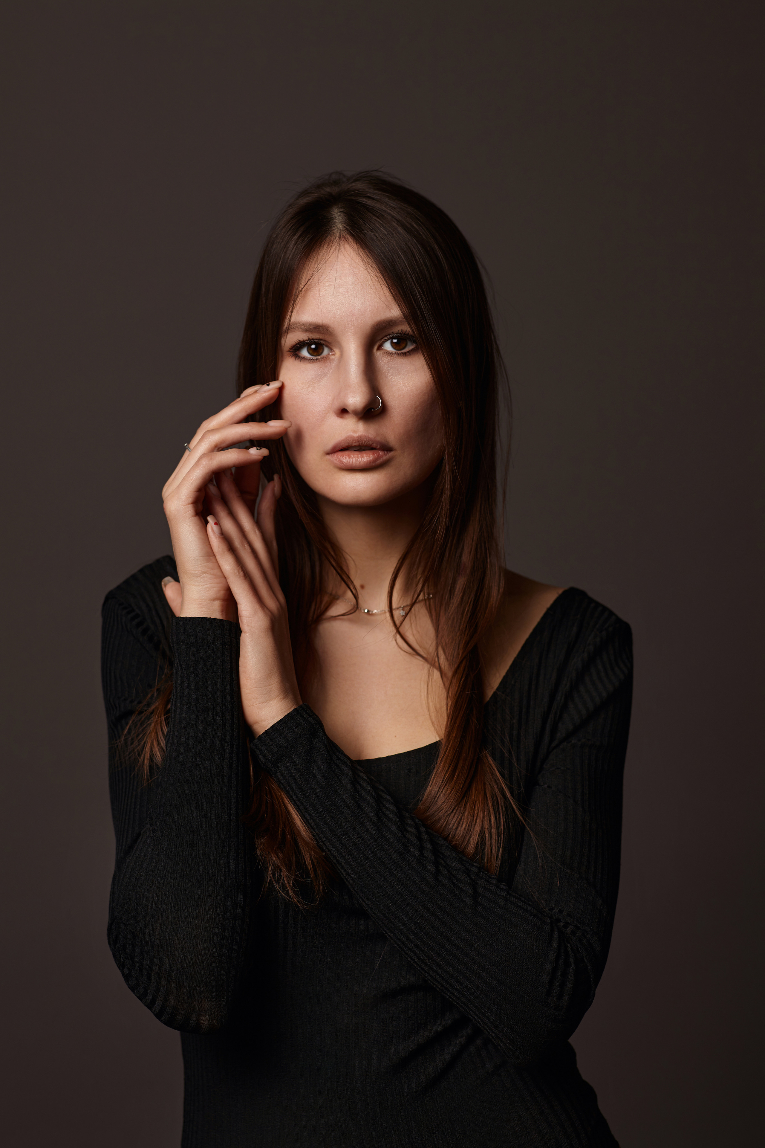 Девушка в студии на темном циклорамном фоне.