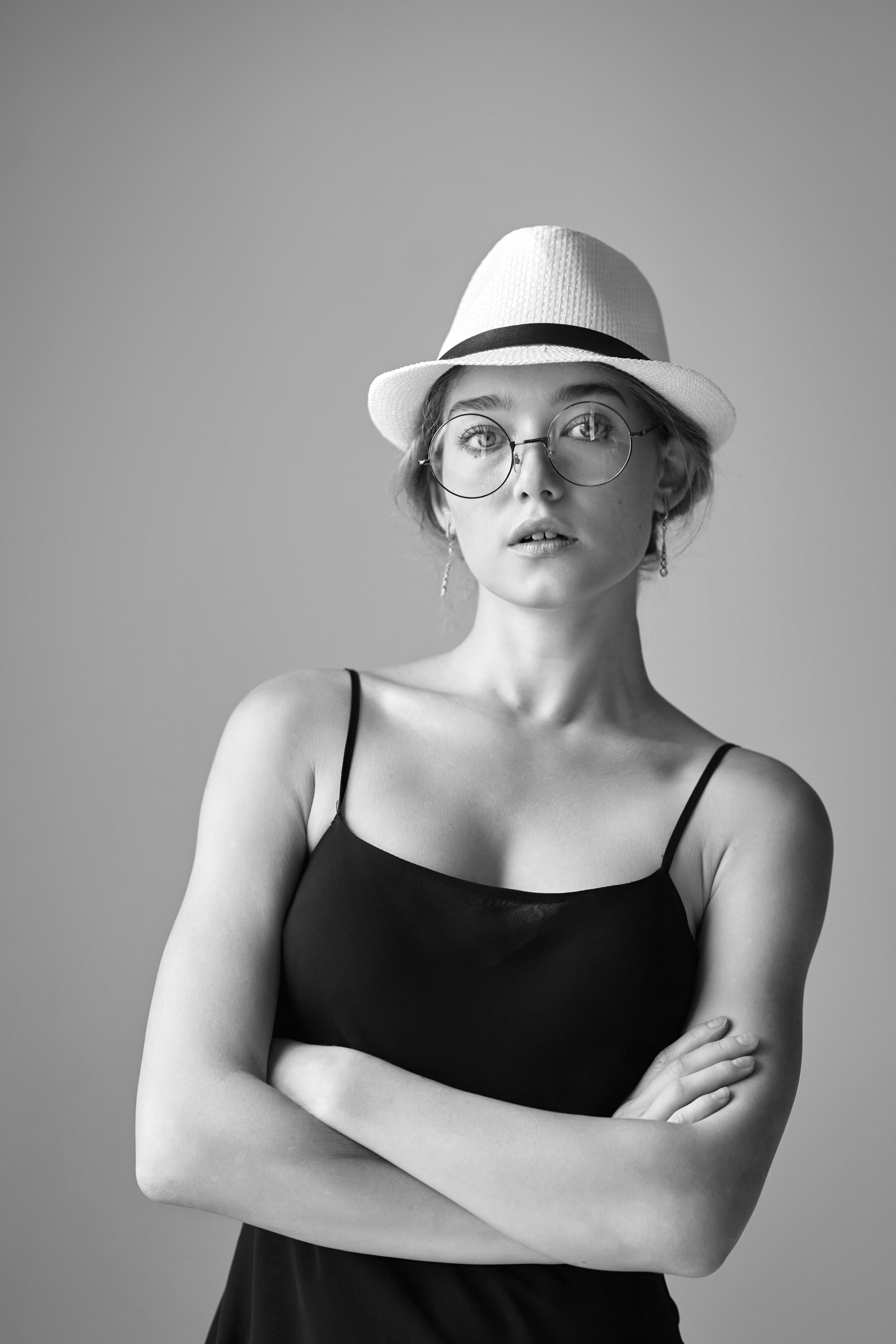 Улыбающаяся светловолосая модель Алиса в свободной рубашке на светлом фоне студии.