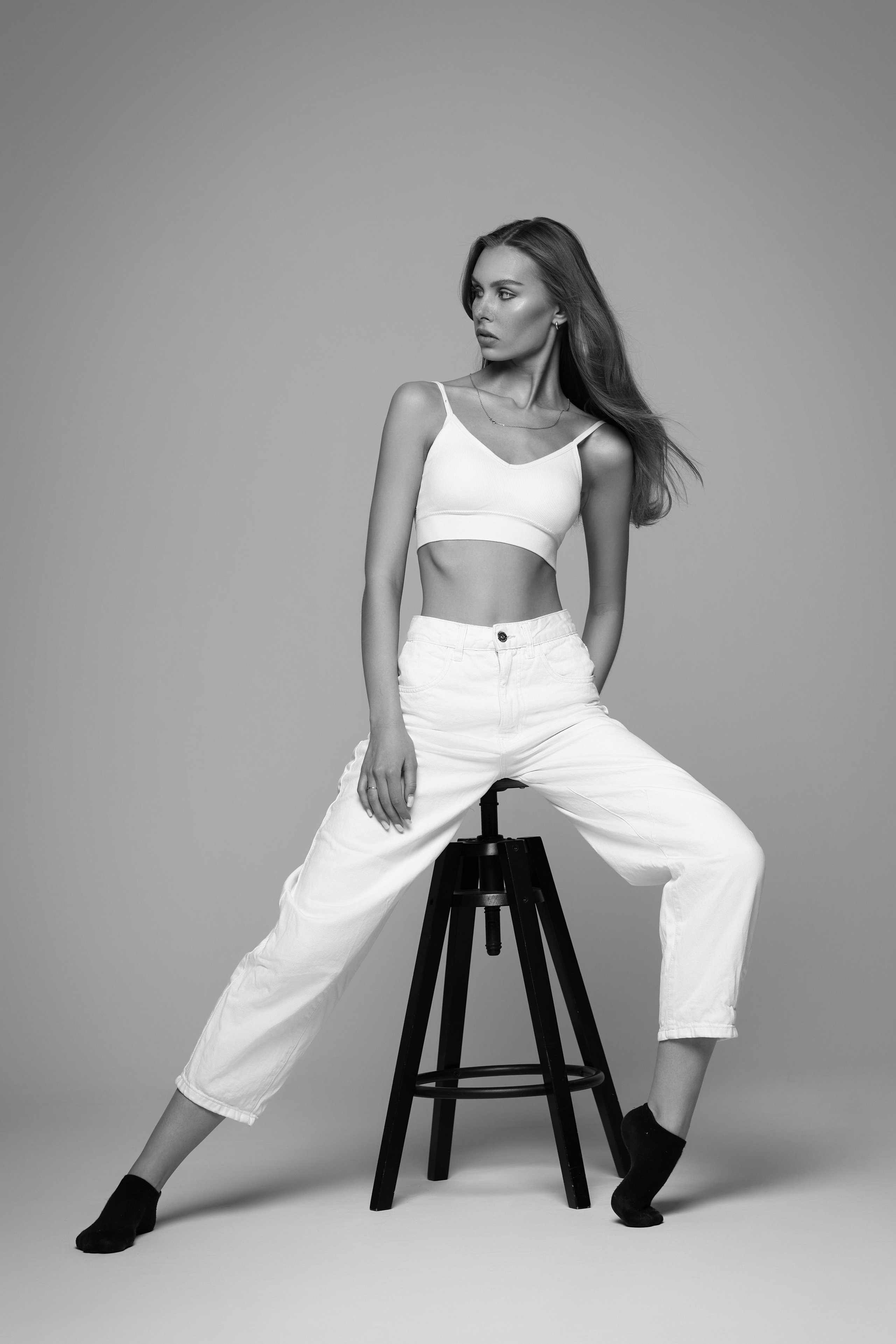 Темноволосая красавица в очках на светлом фоне студии.