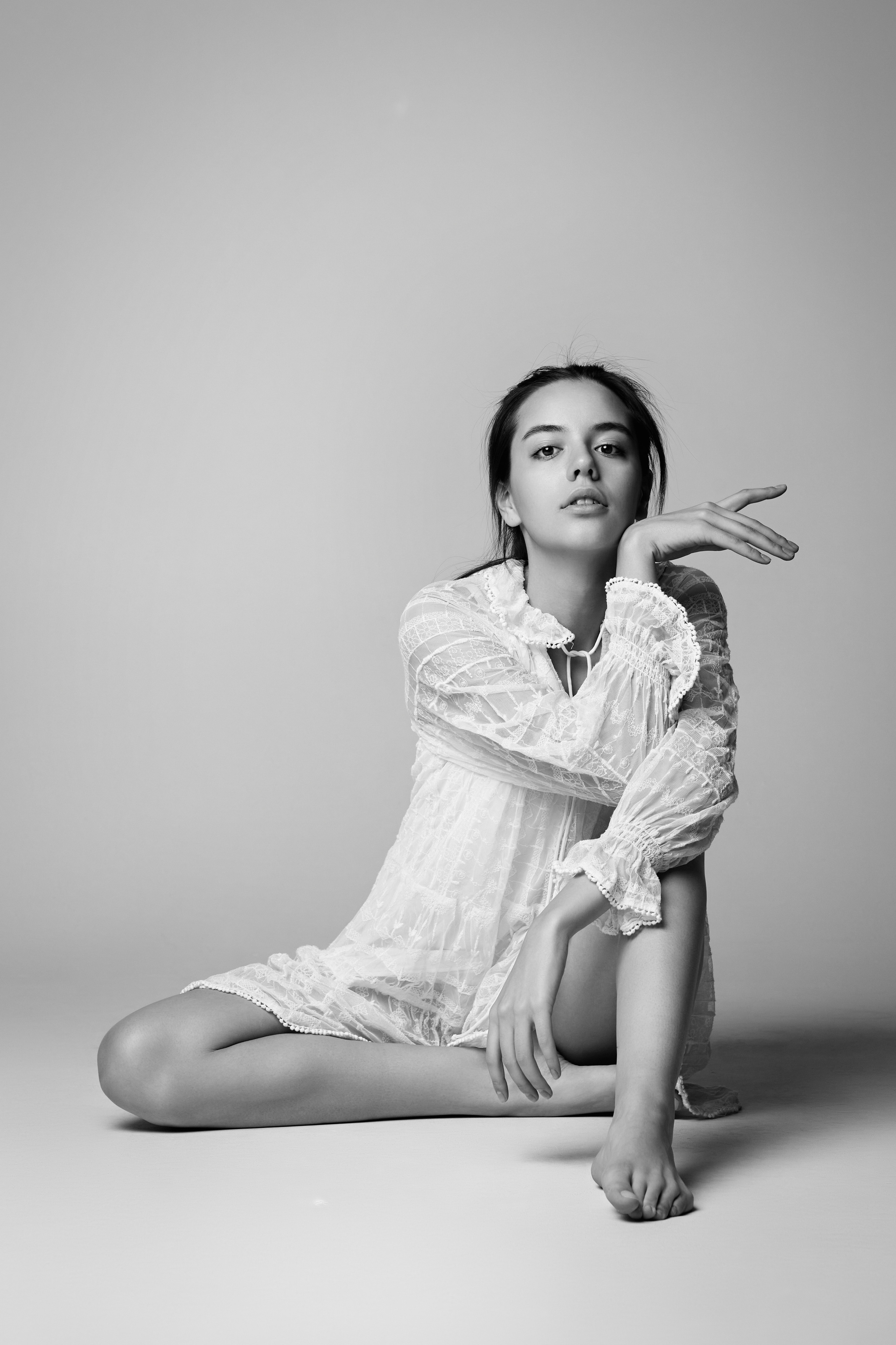 Красивая Амина в светлом наряде на фоне студии с ярким образом.