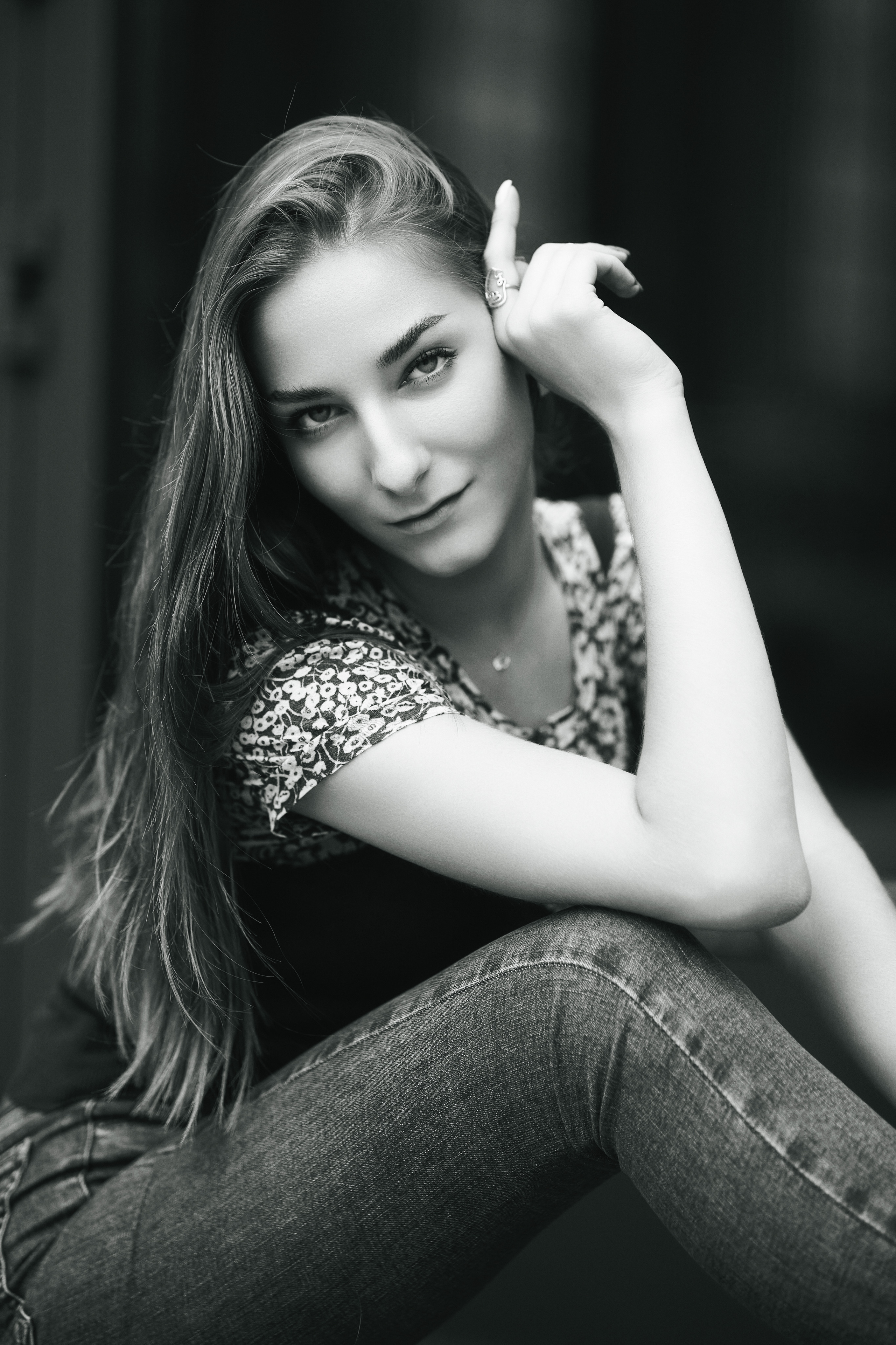 Темноволосая Любовь, позирующая на фоне городской среды в изысканном платье или удобных джинсах.