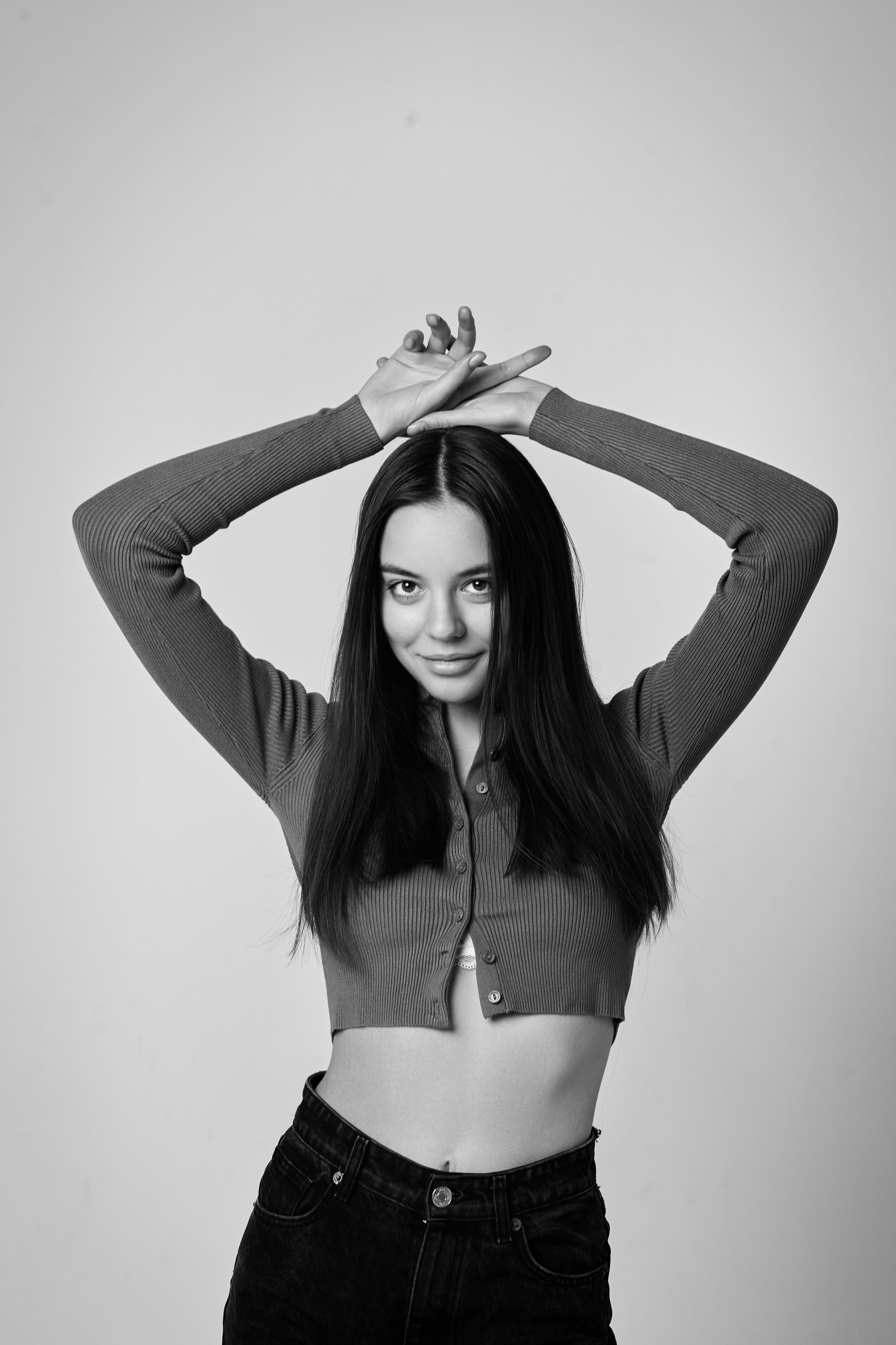 Темноволосая модель Амина на светлом фоне в светлом платье выглядит свежо и нежно.