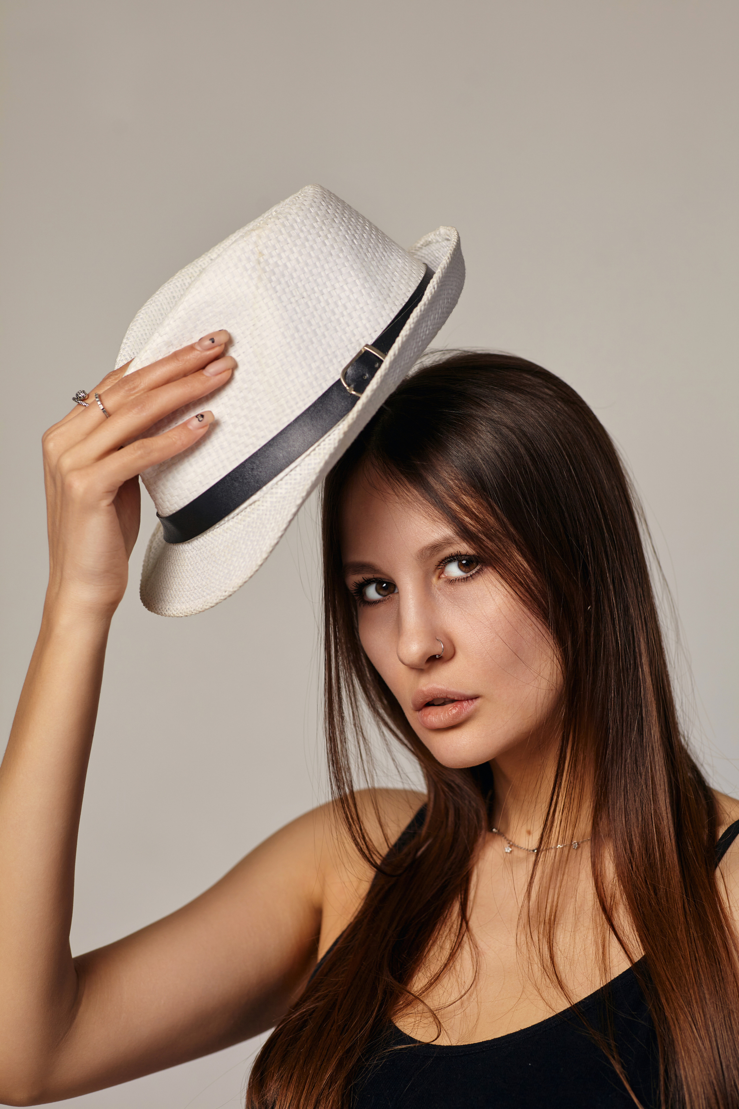 Темноволосая модель в фотостудии на светлом фоне