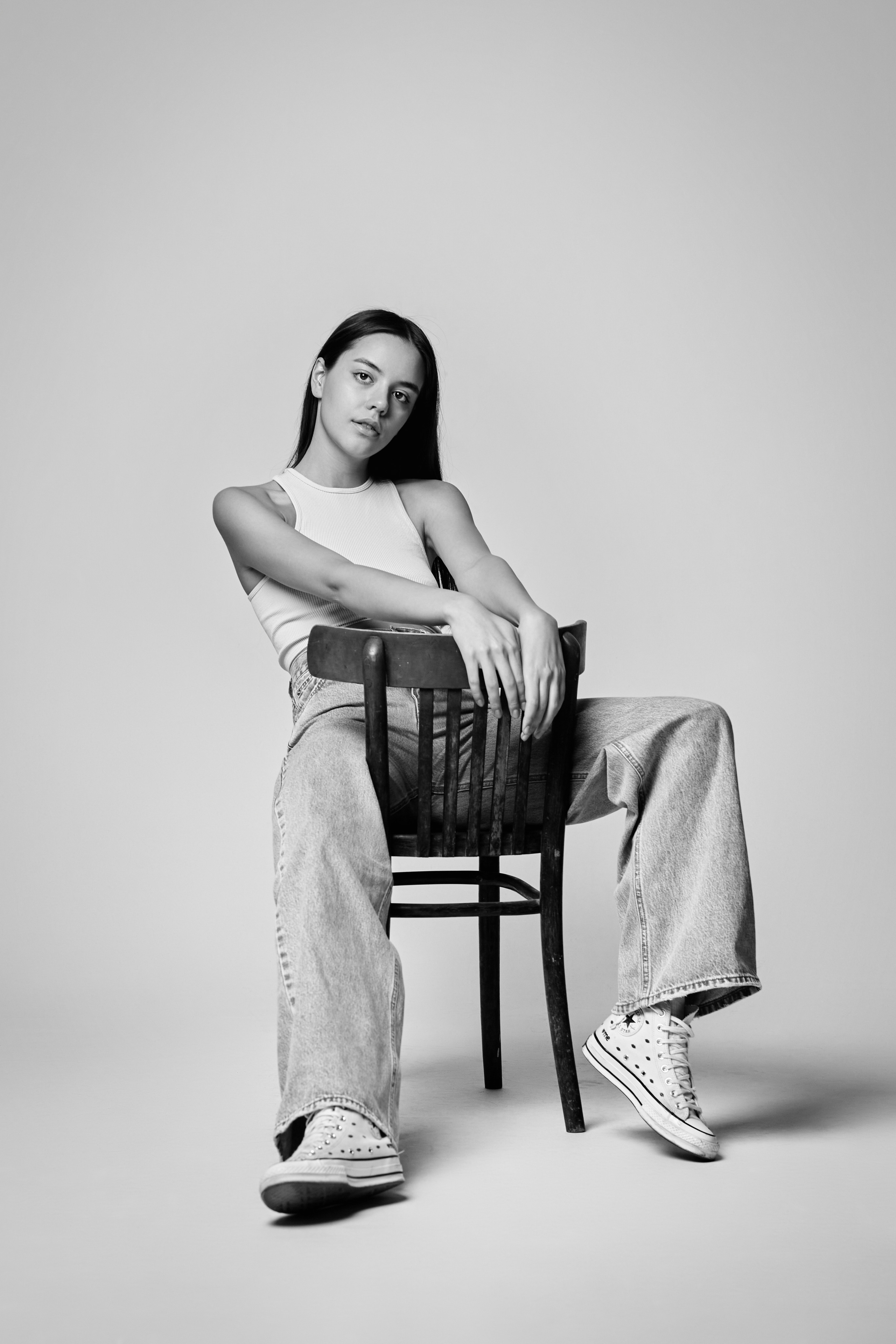 Нежная темноволосая модель Амина на светлом фоне в светлом платье привлекает внимание.