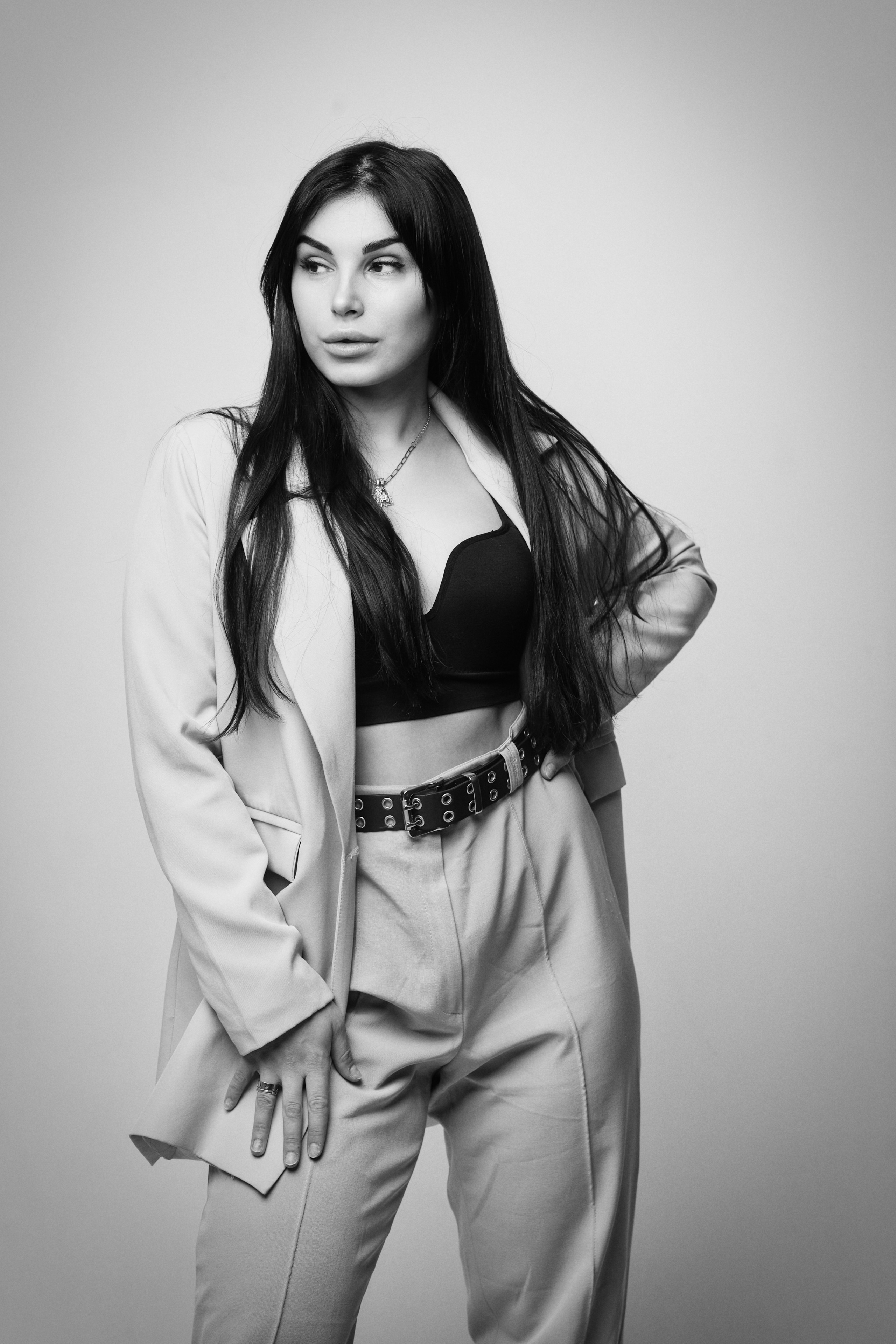 Карина - модель с элегантным стилем в костюме на светлом фоне в студии.