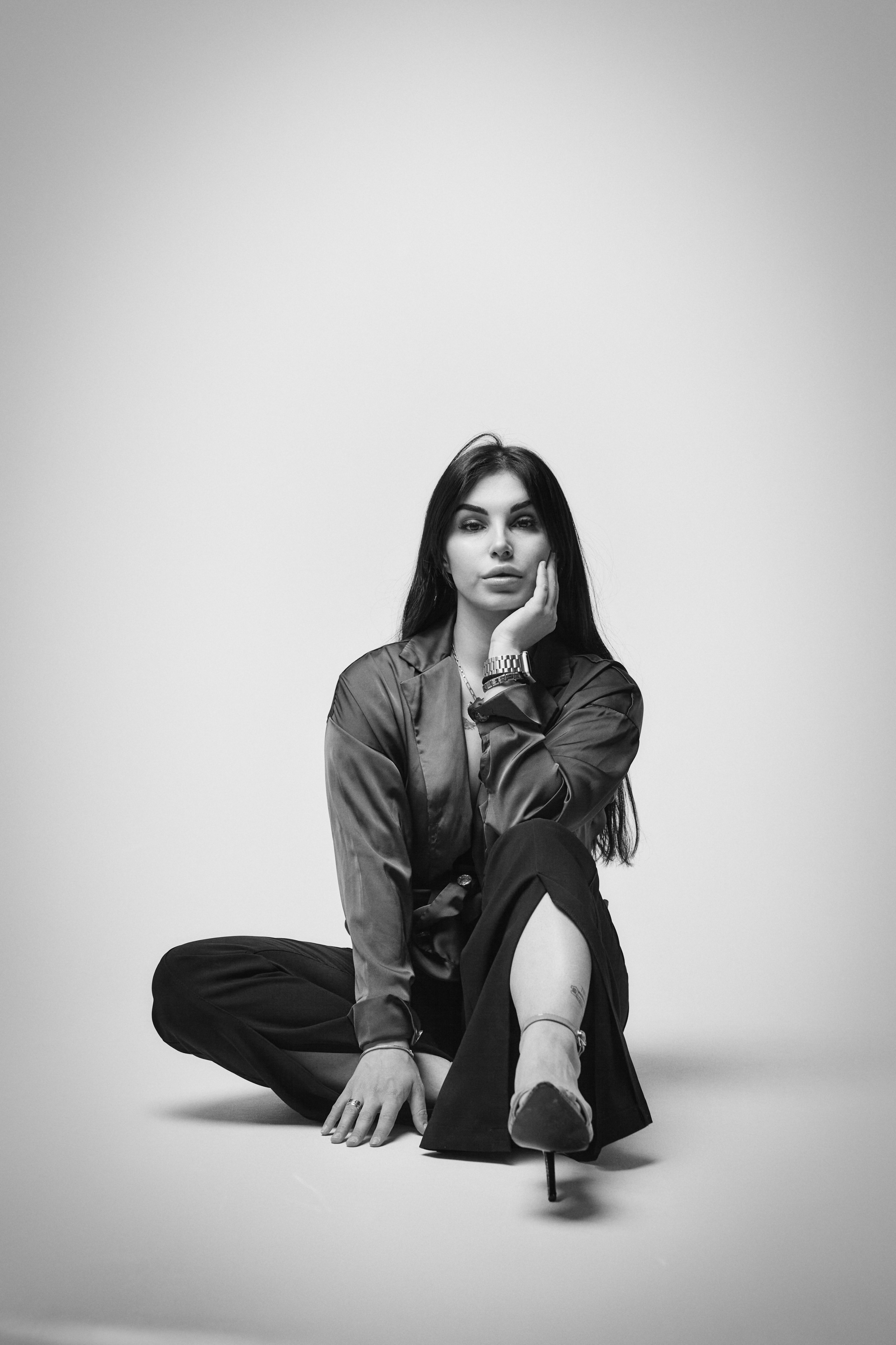 Темноволосая модель Карина в костюме на светлом фоне студии, сильный и уверенный образ