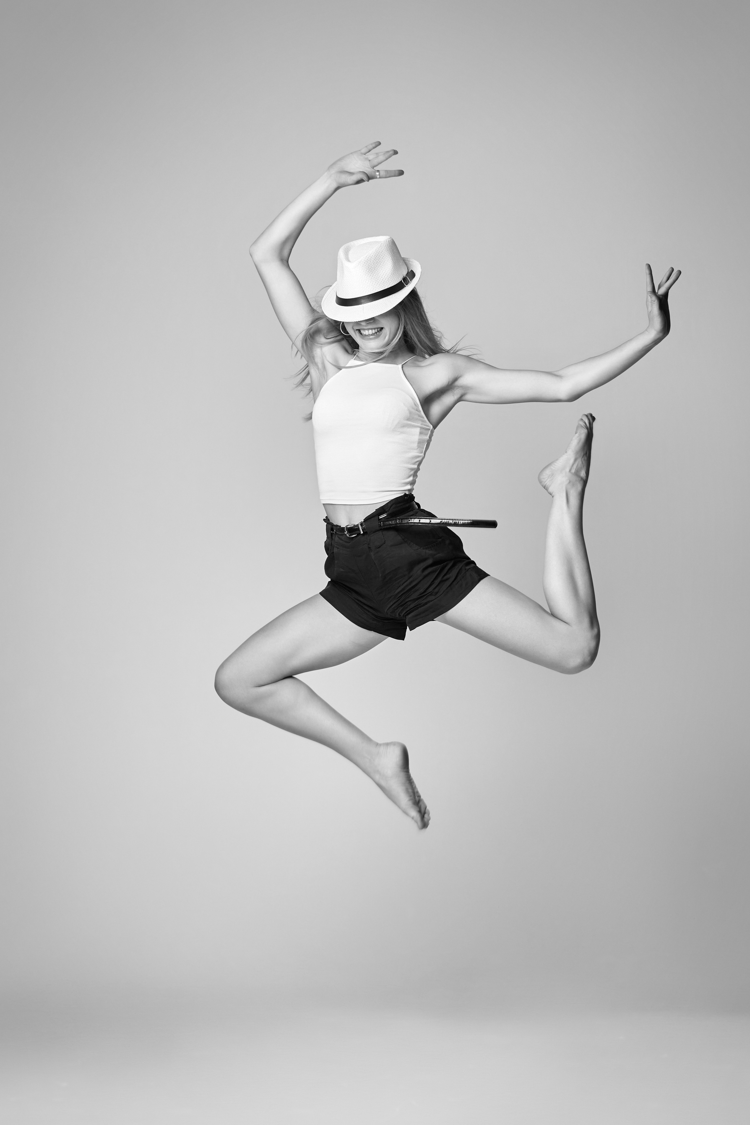 Портрет светловолосой модели Алисы в студии на светлом фоне в рубашке и джинсах, с красным карманом.